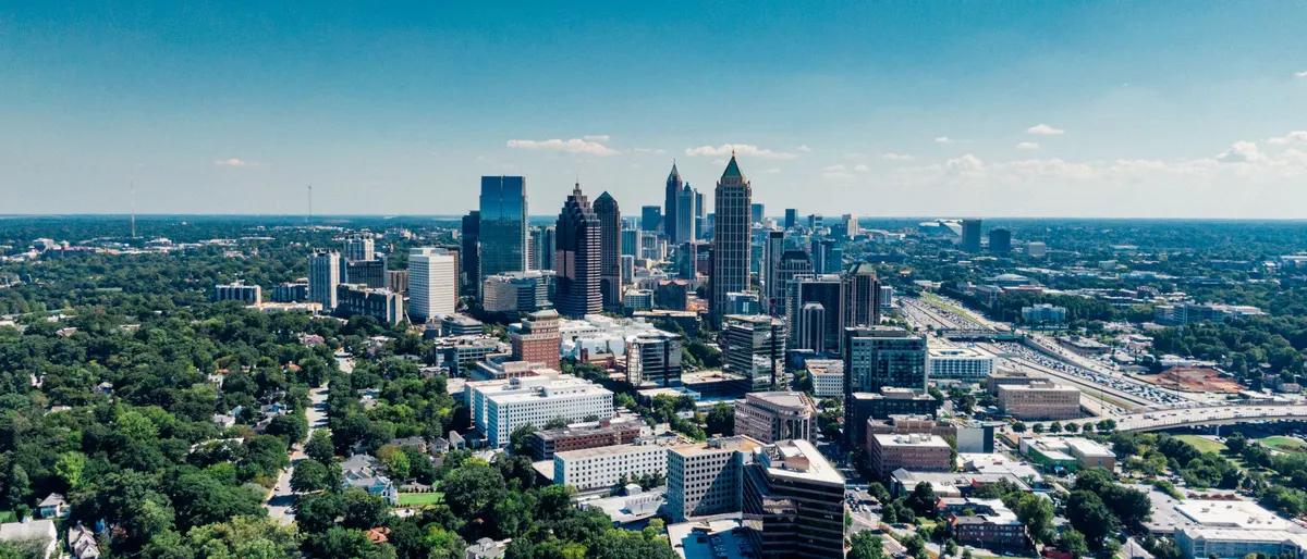An aerial view of the Midtown Atlanta skyline surrounded by tree-lined streets