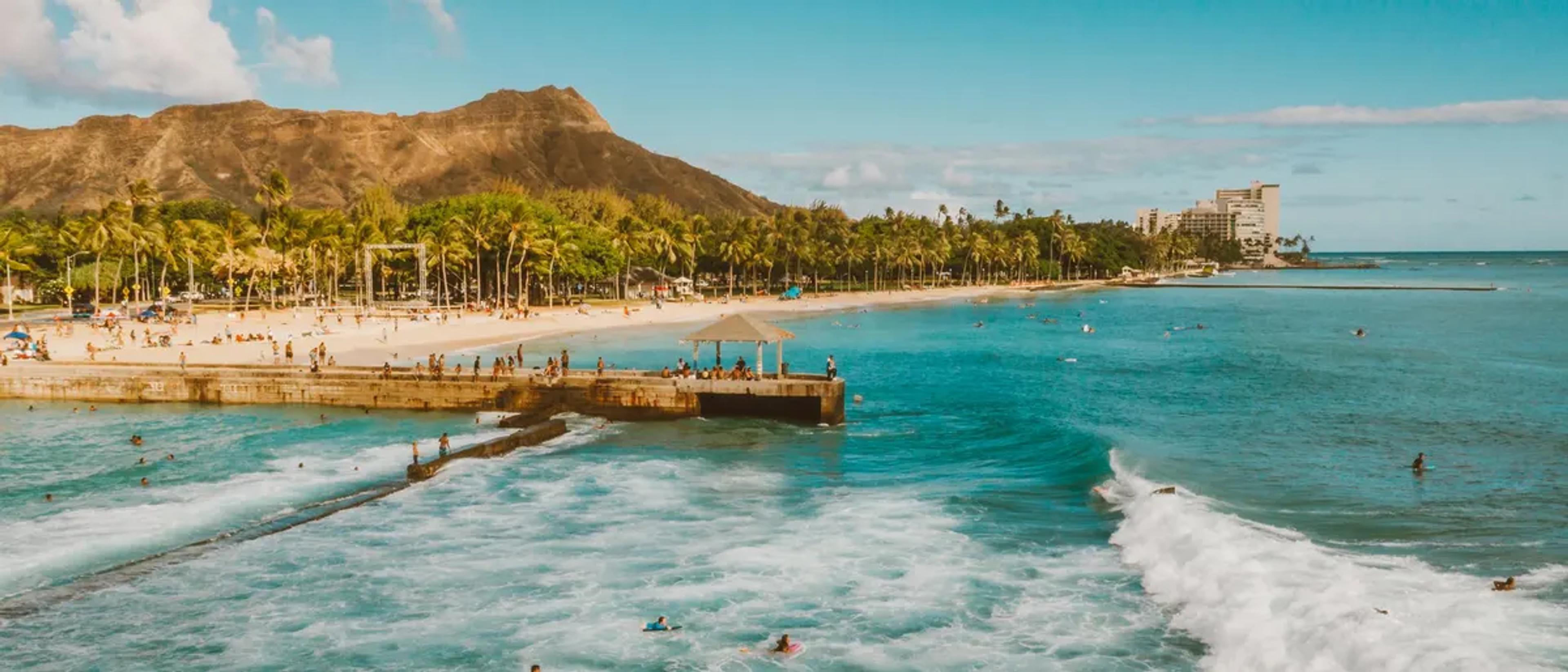 Waikiki Beach and Diamond Head crater in the morning light with surfers in the water