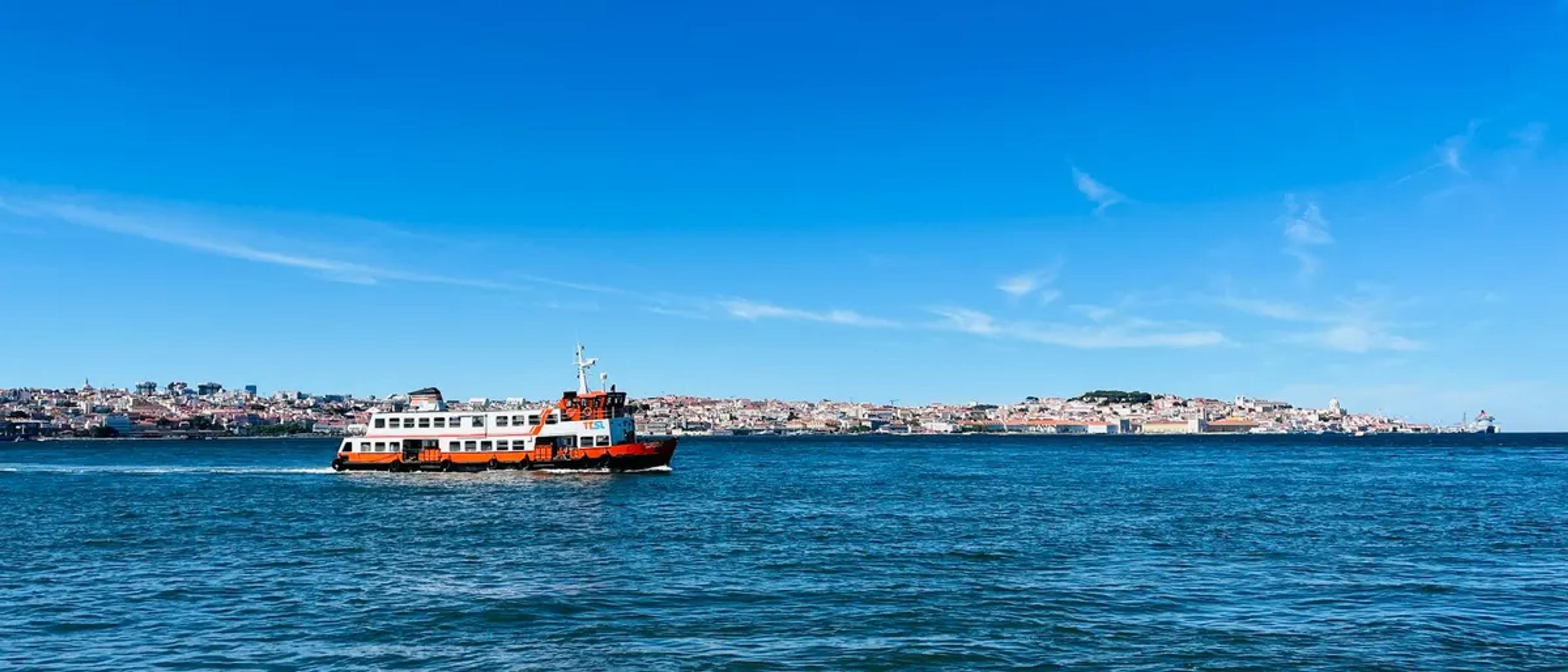 A passenger ferry crossing open bay water toward the shoreline