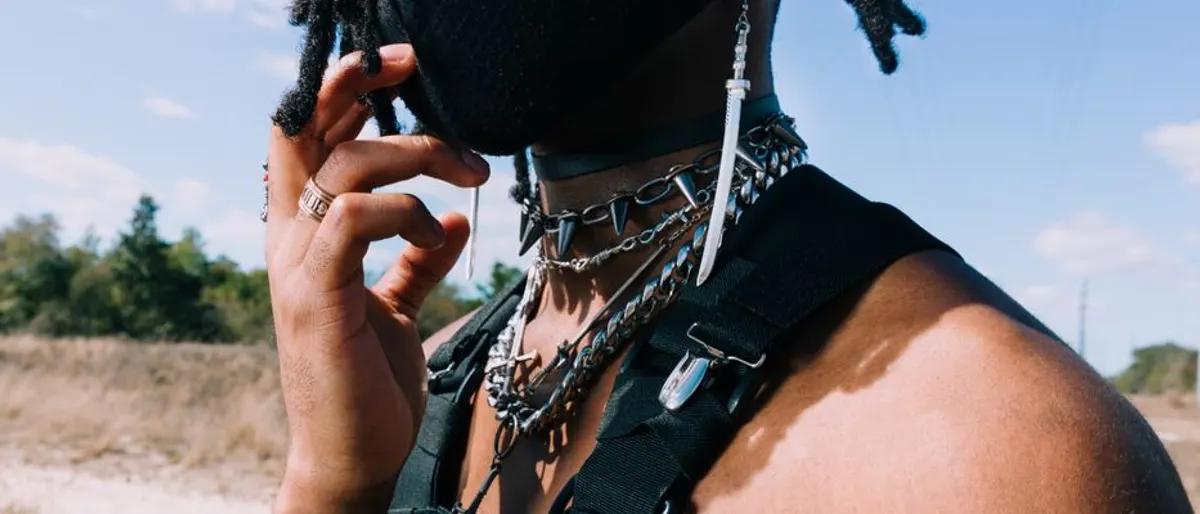 Man wearing a studded leather harness with chains and a collar