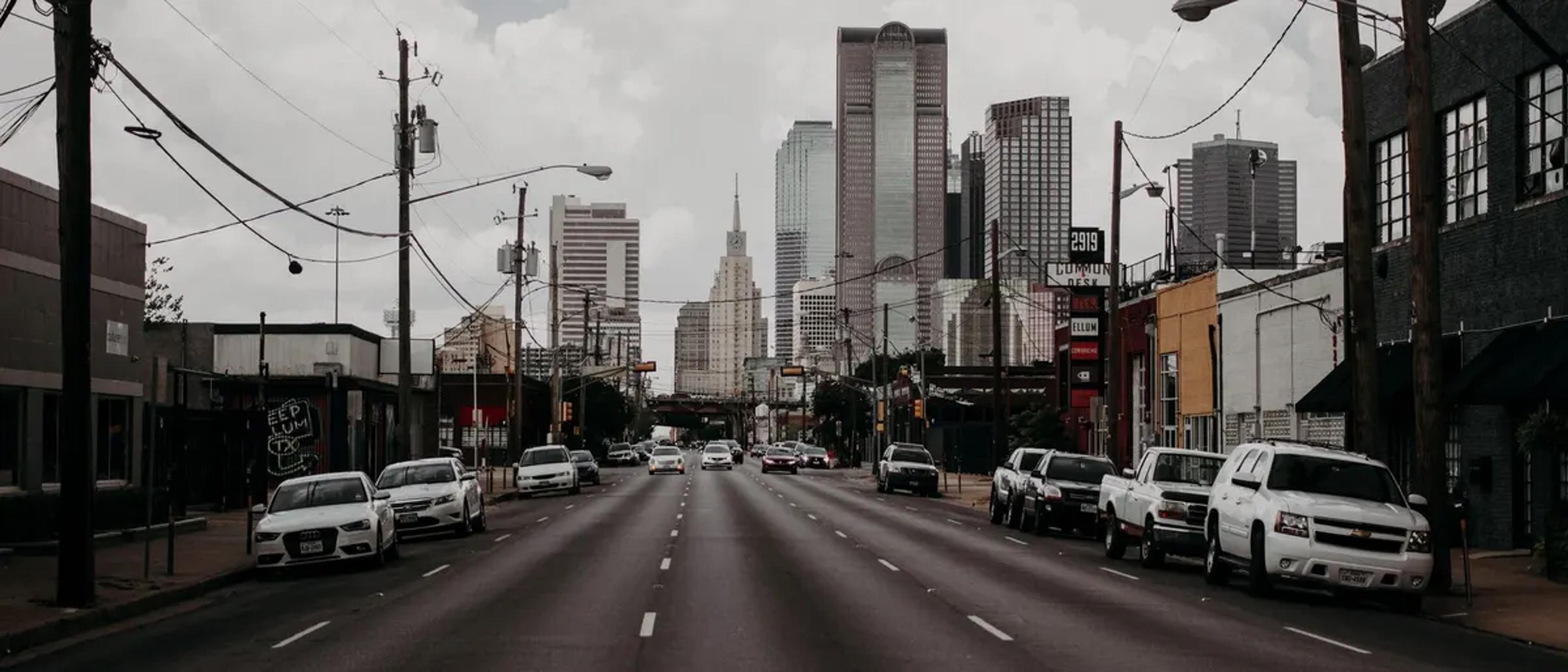 A wide avenue leading toward the downtown Dallas skyline near Oak Lawn