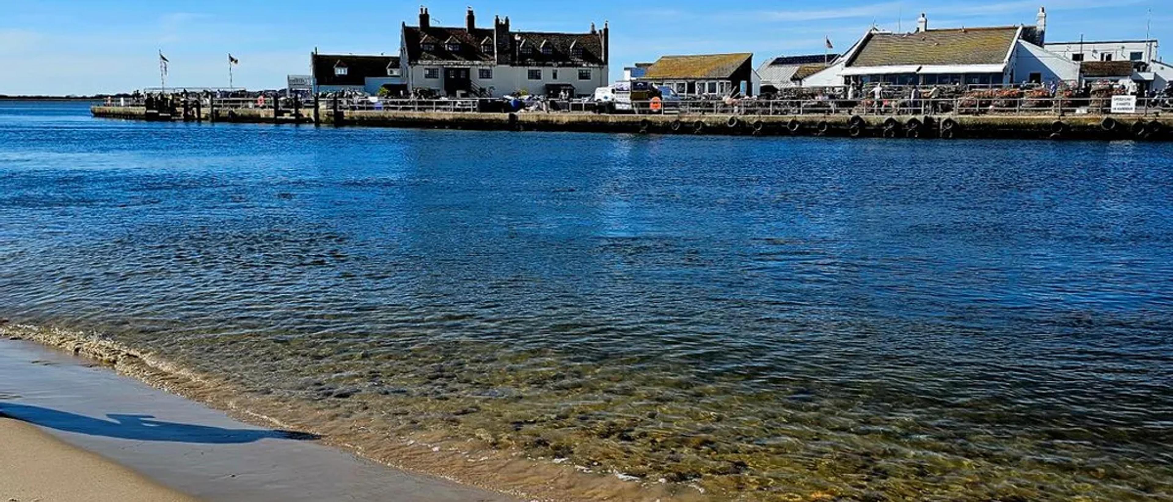 Provincetown harbor waterfront with weathered buildings across calm blue water