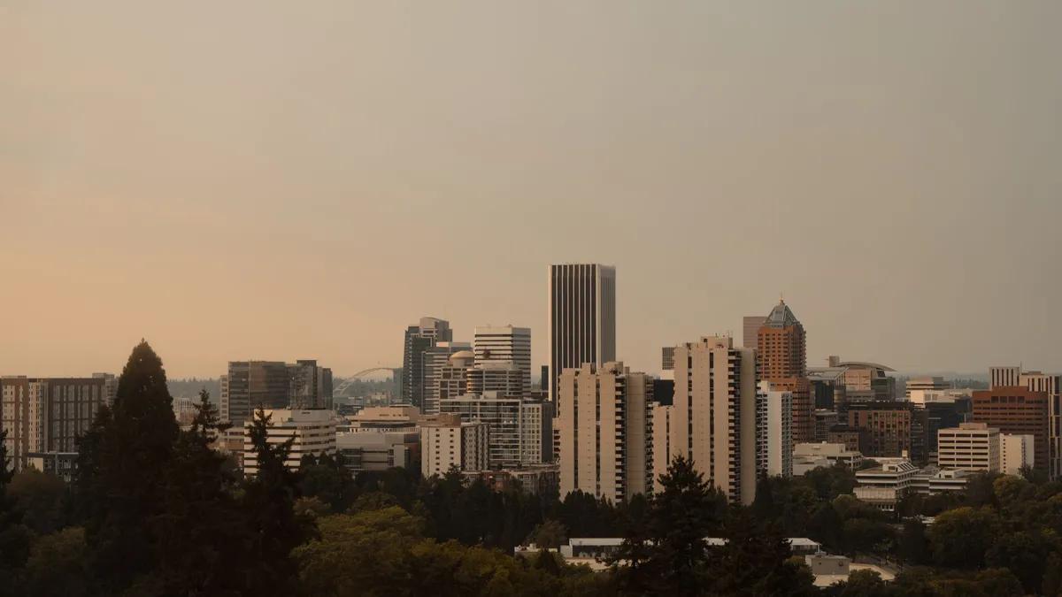 The downtown Portland, Oregon skyline framed by evergreens at sunset