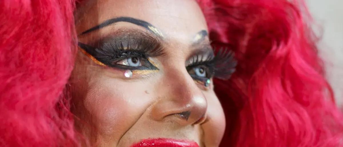Expressive drag performer with pink hair and dramatic makeup