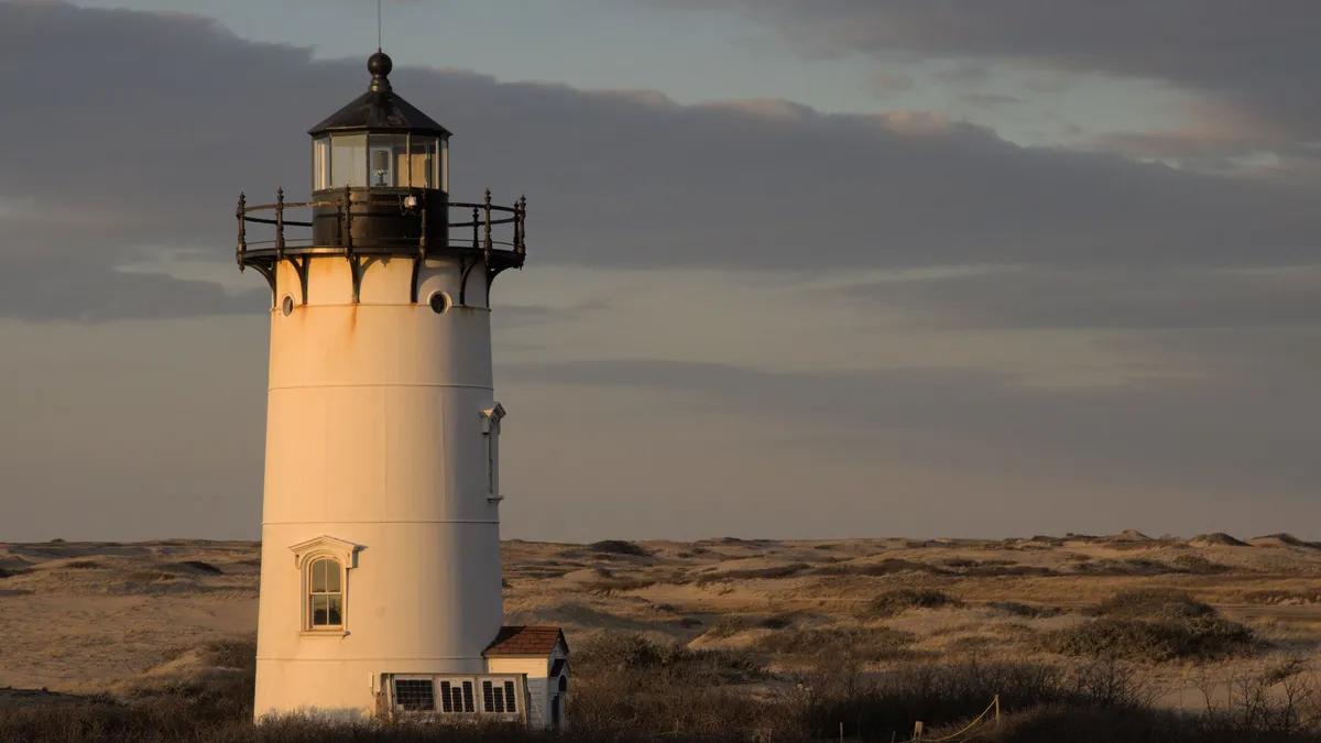 Race Point Lighthouse standing in the dunes outside Provincetown, Massachusetts, at golden hour