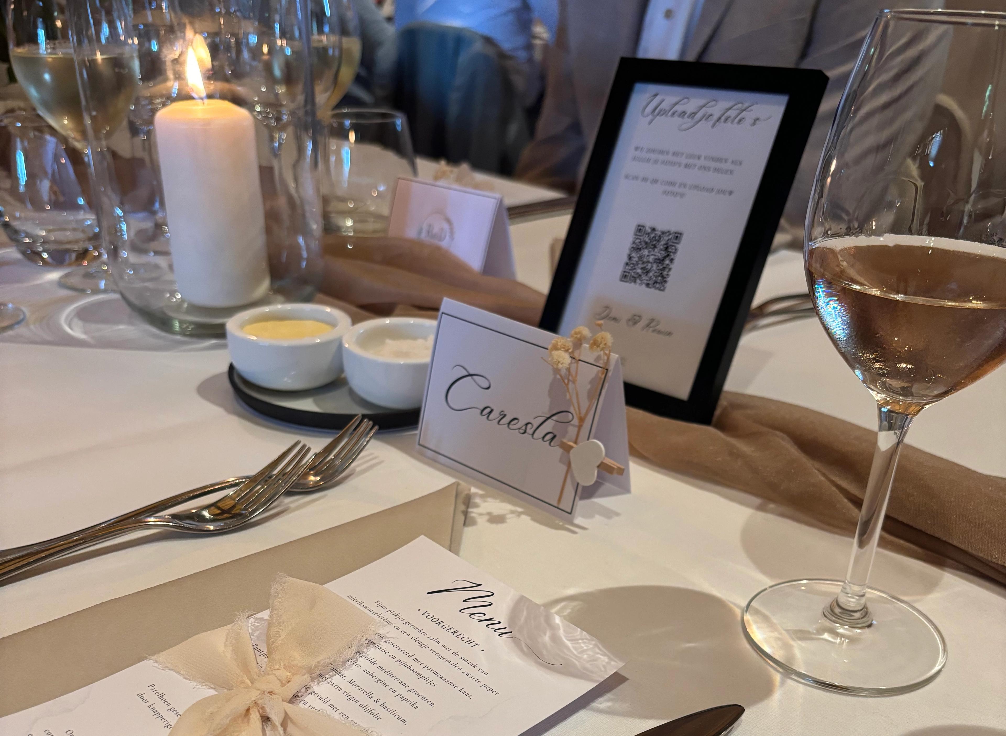 Gedekte trouwtafel met een bordje met QR-code waarmee gasten foto's uploaden