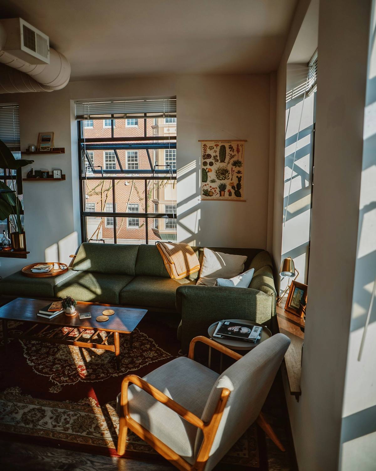 A living room with a sofa, an armchair and a patterned rug by the window