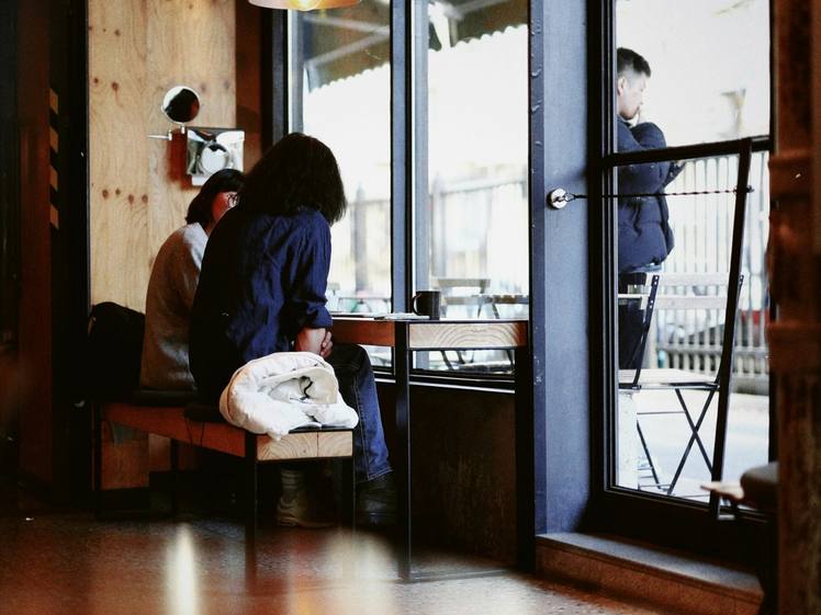 A bright room with wooden floors and tall windows onto a balcony