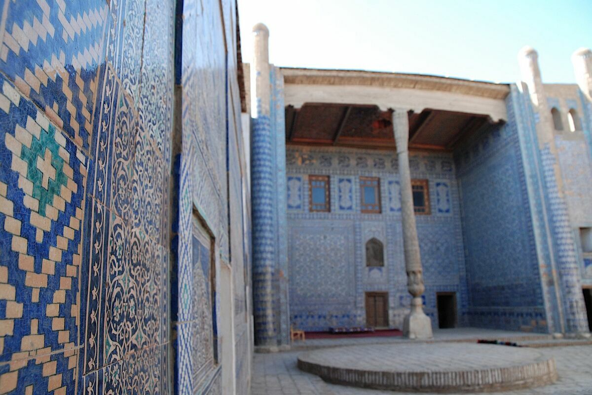 Harem nel Konya Ark a Khiva, Uzbekistan: Magnifico cortile con piastrelle a mosaico blu e colonne intagliate.