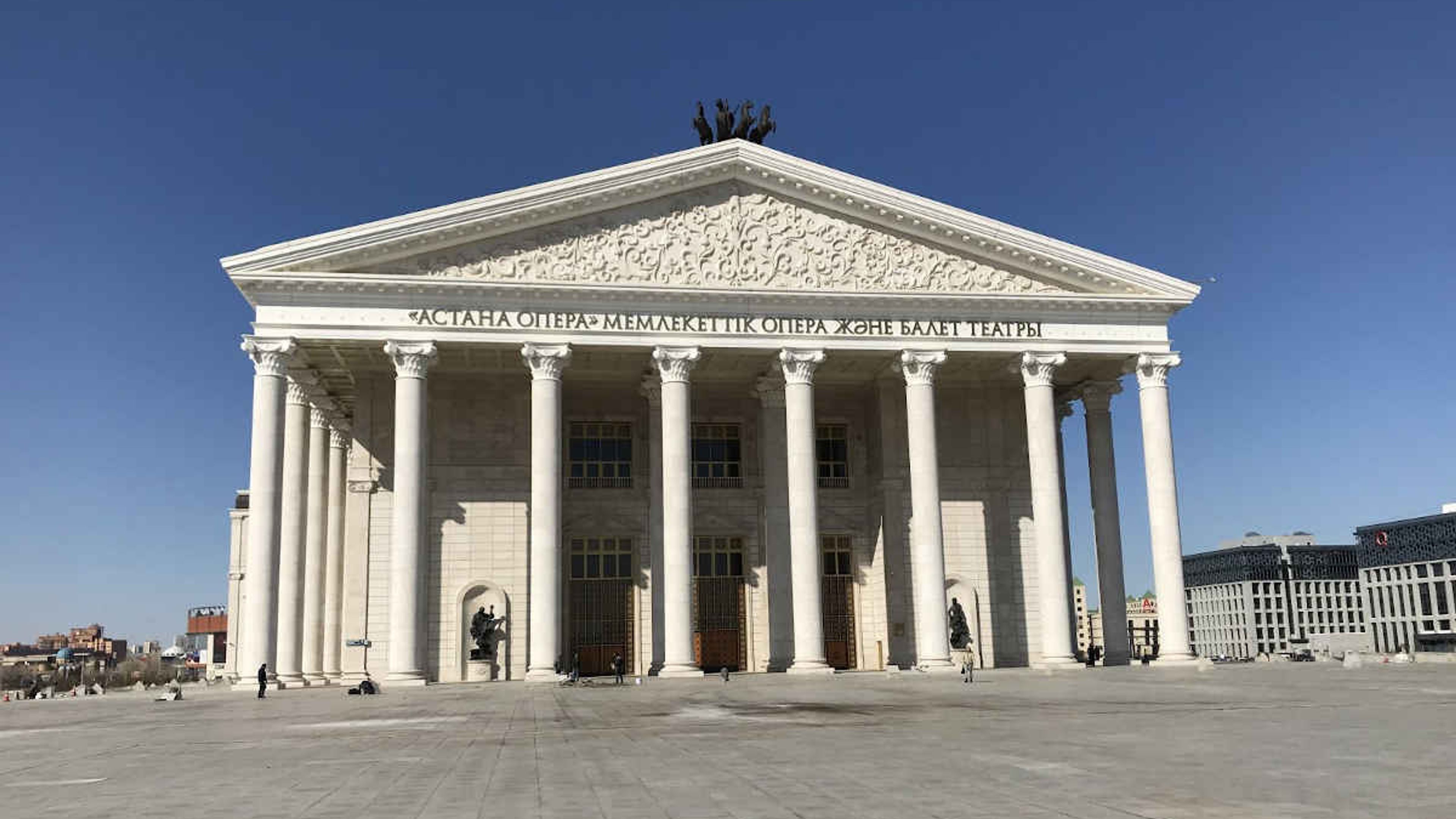 Imposing facade of the Astana Opera in Kazakhstan, a famous tourist attraction with classical columns.