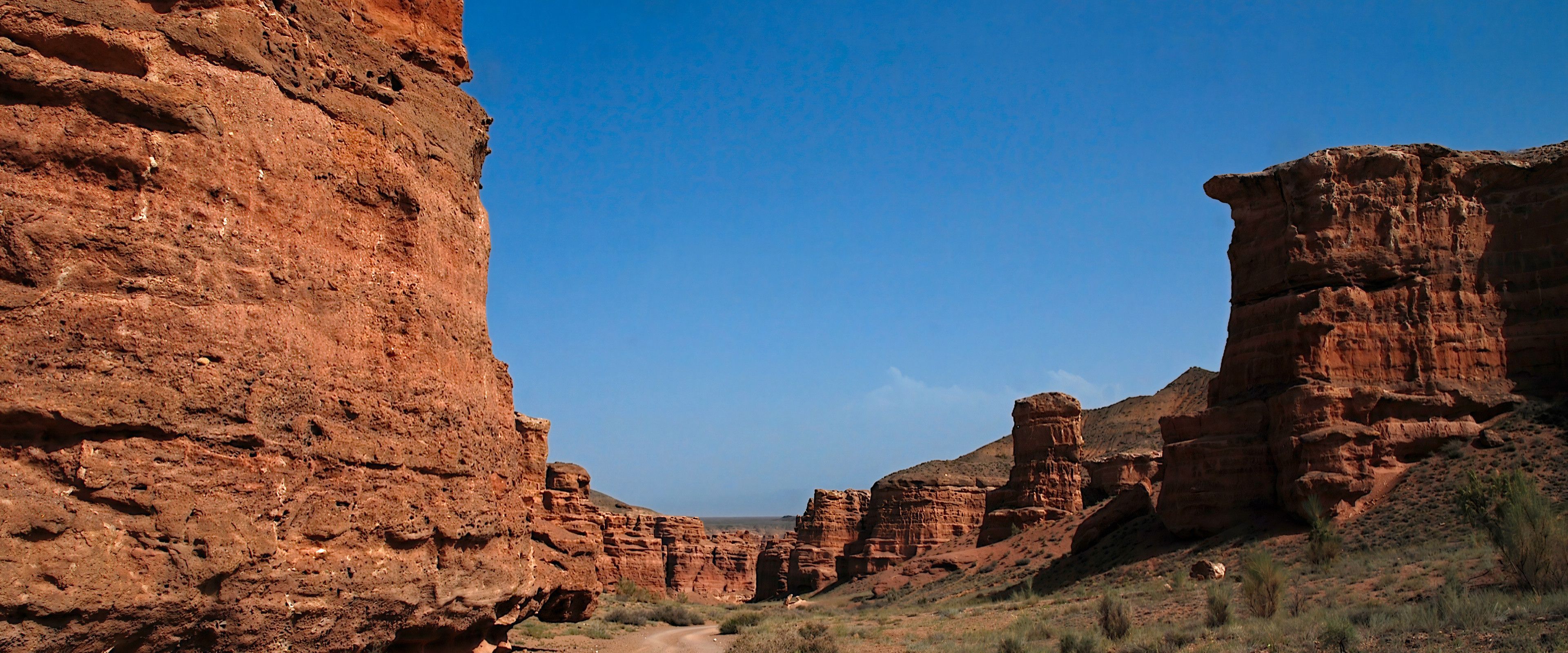 Imposante Felsformationen des Charyn-Canyons in Kasachstan bei blauem Himmel.