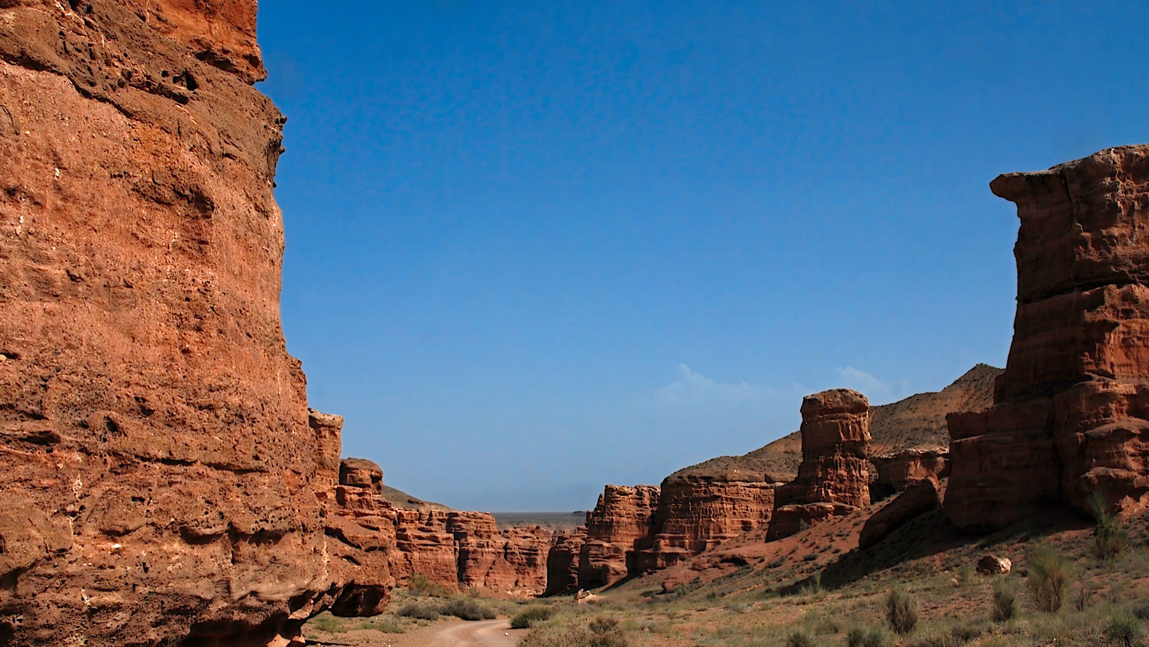 Imposante Felsformationen des Charyn-Canyons in Kasachstan bei blauem Himmel.