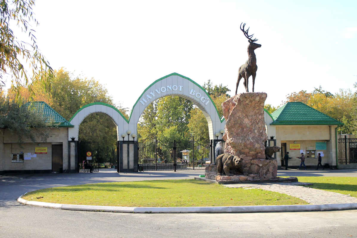 Entrée principale du zoo de Tachkent en Ouzbékistan avec des statues d'animaux et des arches.