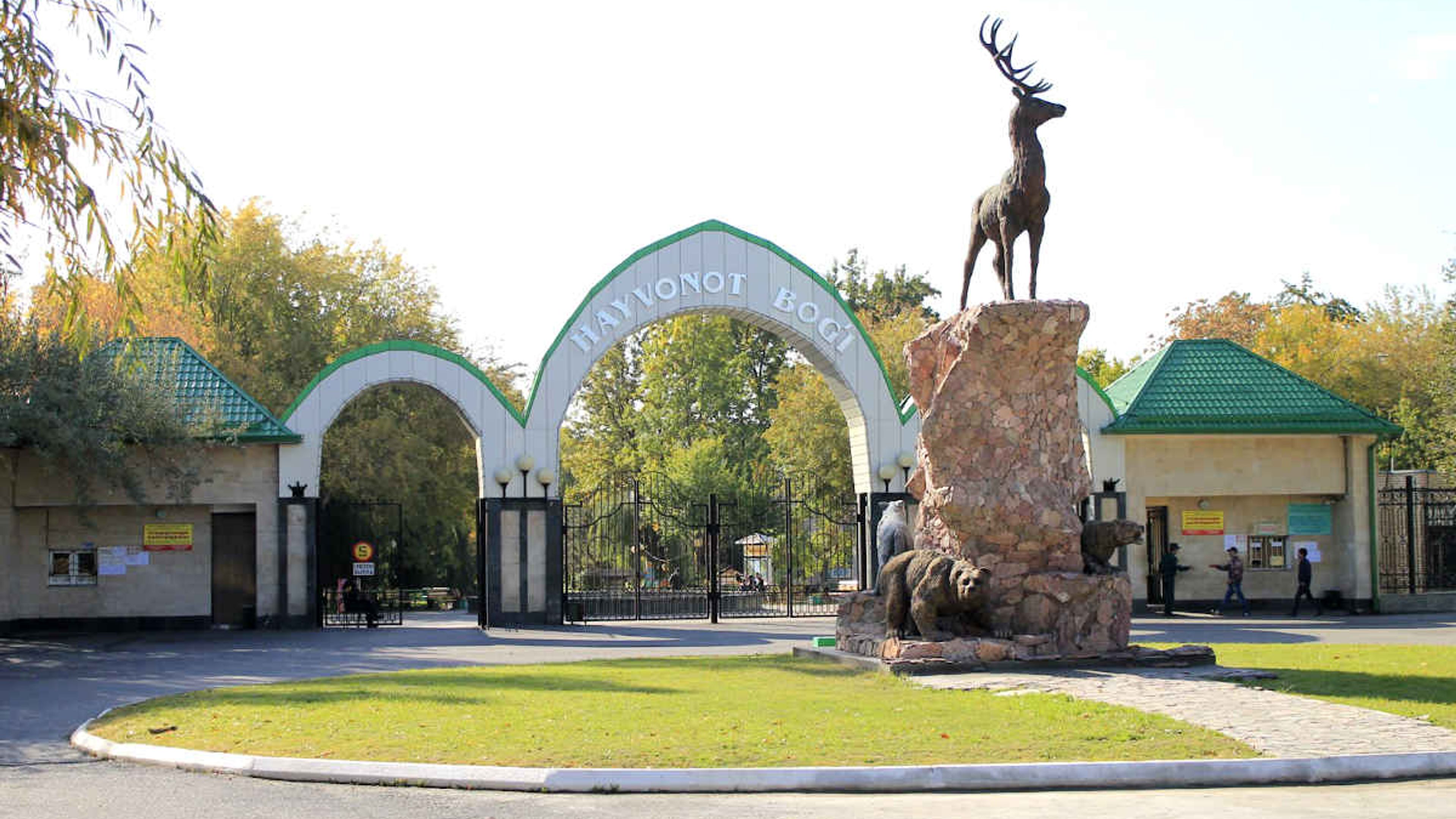 Entrée principale du zoo de Tachkent en Ouzbékistan avec des statues d'animaux et des arches.