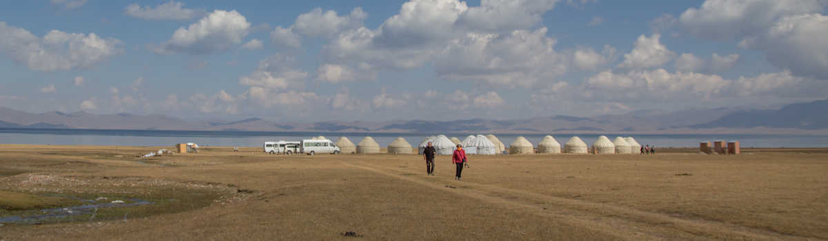 Escursionisti davanti a un campo yurta al lago Song Köl in Kirghizistan, viaggio in Asia Centrale