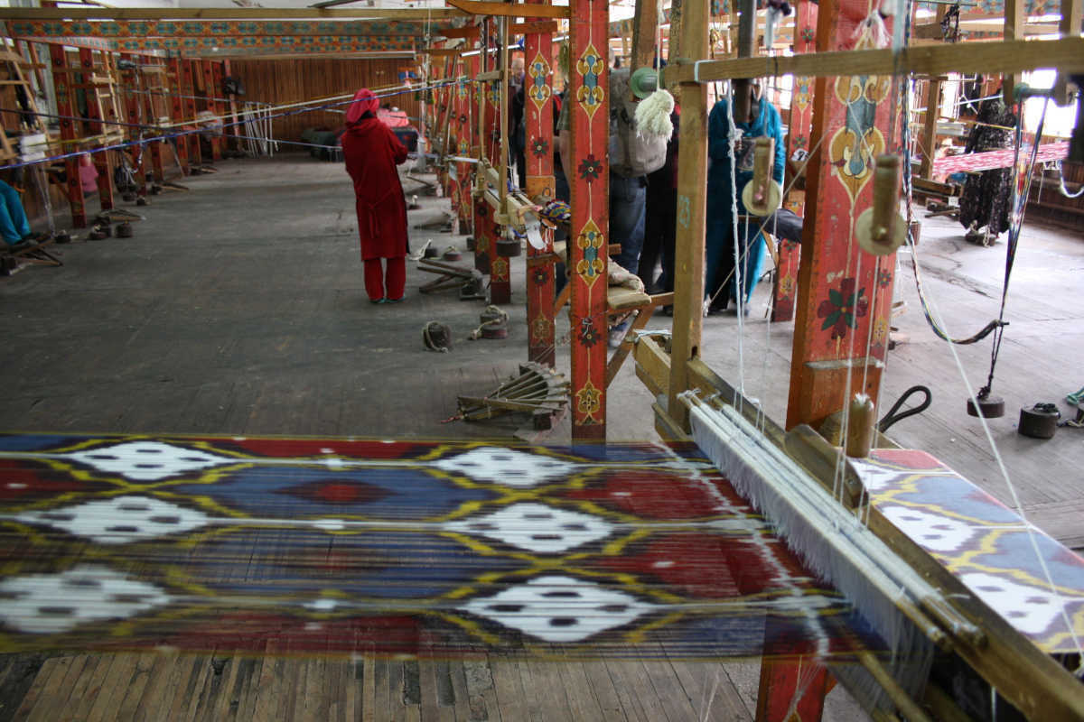 Traditional handloom weaving Khan Atlas silk in Uzbekistan, Central Asia. Artisan silk production.