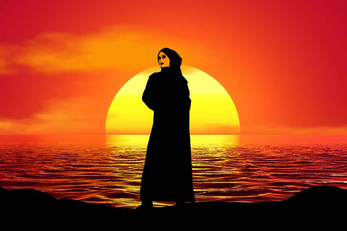 Femmes en Islam : Silhouette d'une femme voilée au coucher du soleil sur la mer Caspienne en Asie Centrale.