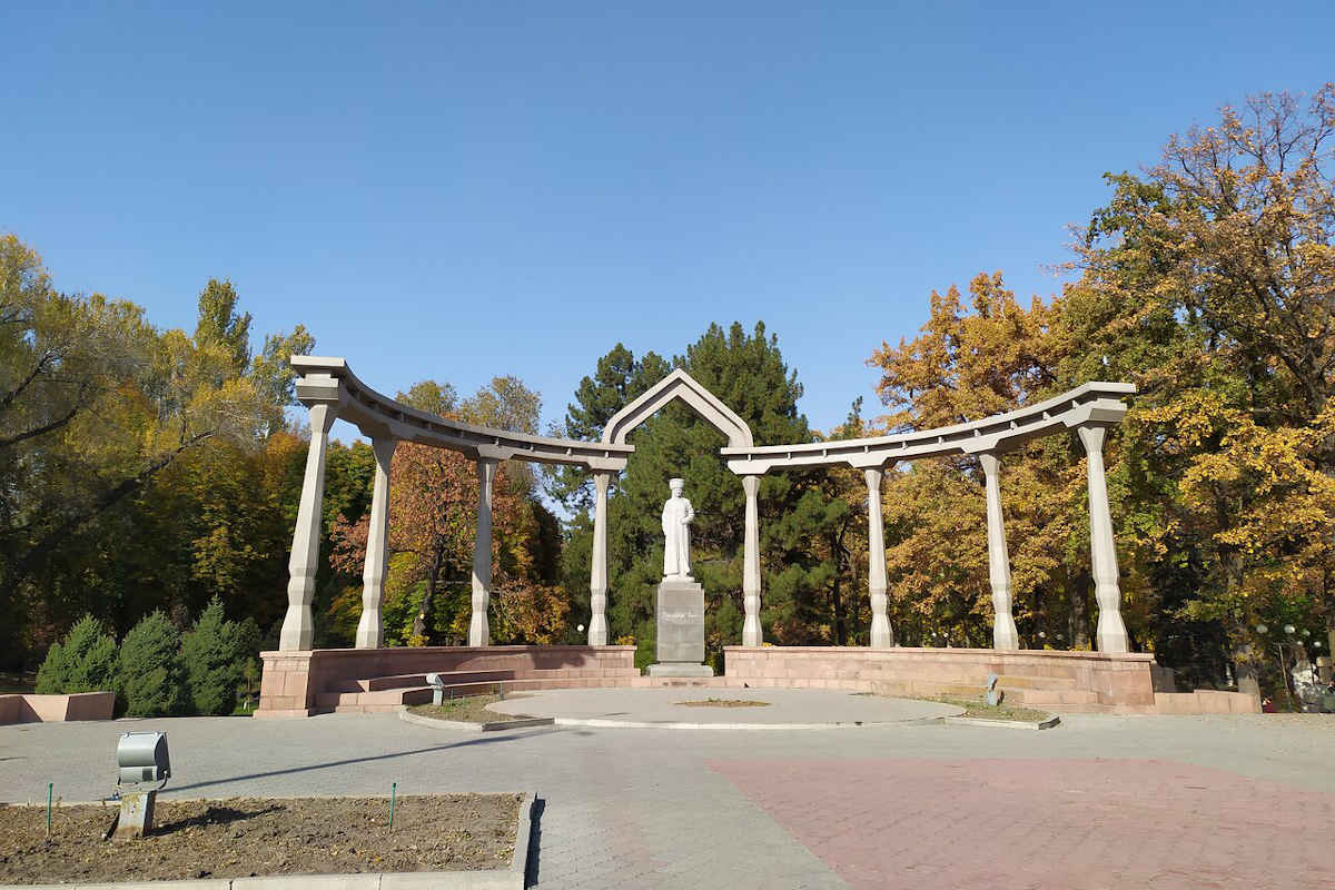 Monument in Oak Park in Bishkek, Kyrgyzstan. A tourist attraction with columns and a statue in the autumn park.