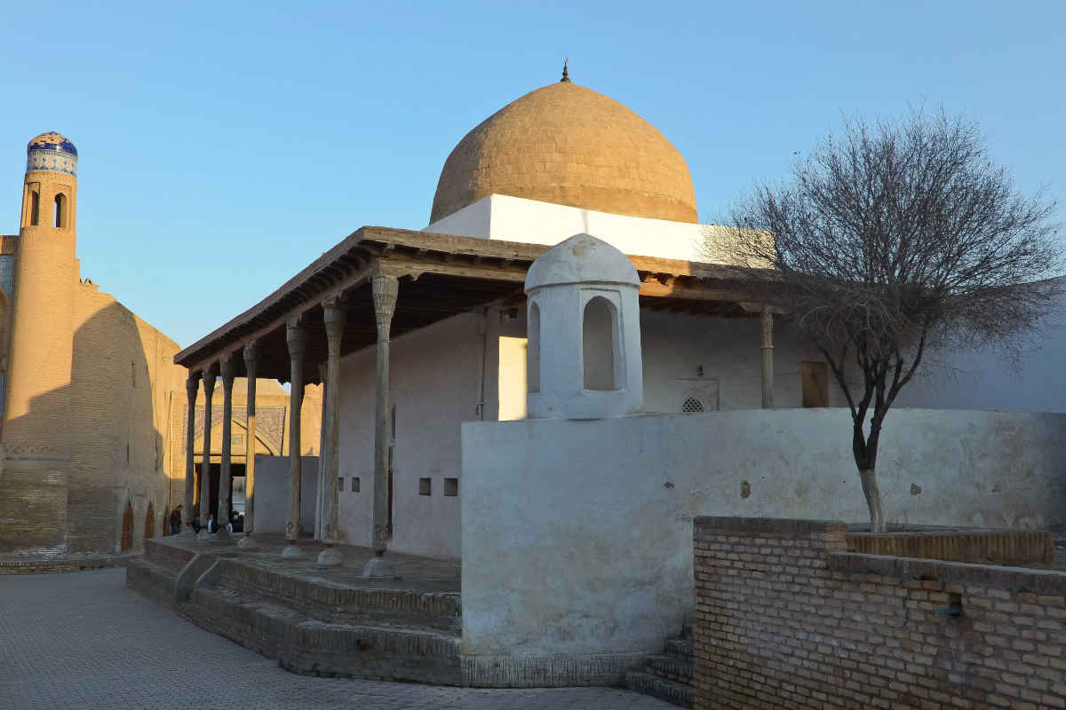 Historical Ak Mosque in Khiva, Uzbekistan, featuring a white dome and carved wooden pillars as a UNESCO landmark.