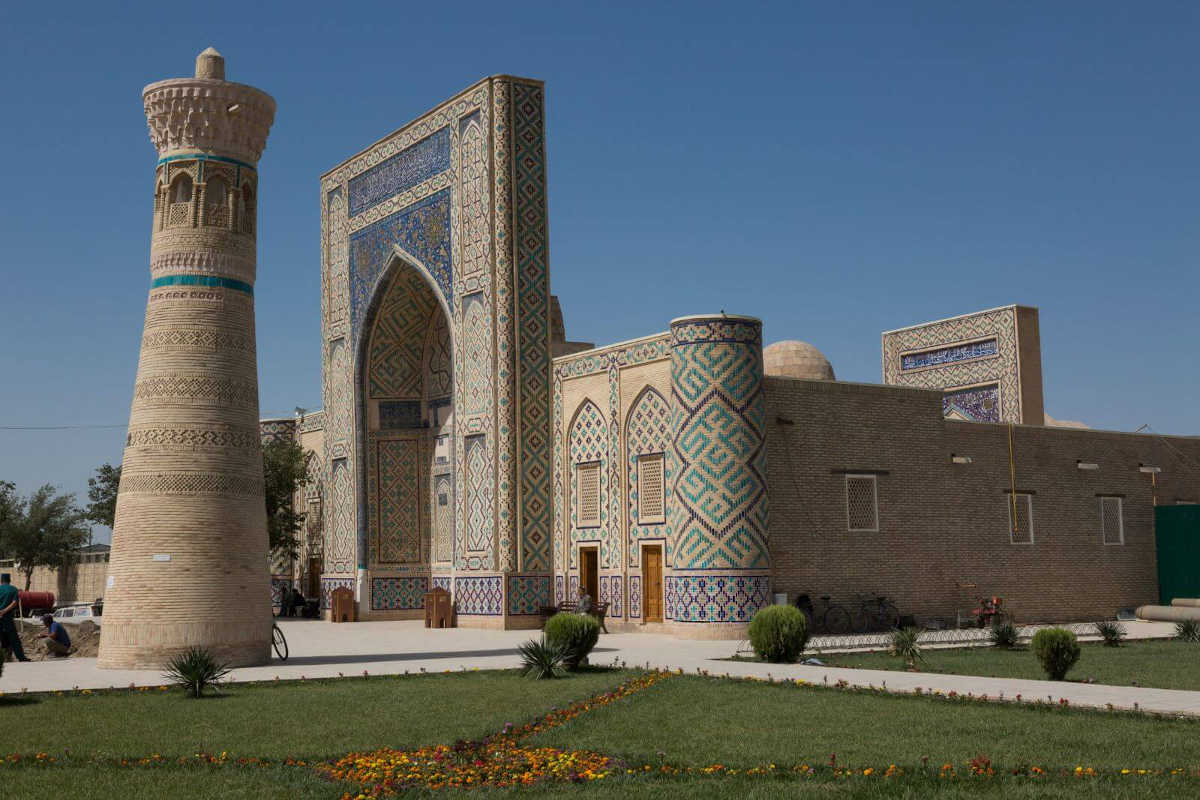 Madrasah Oulougbek à Gijduvan, Ouzbékistan : Monument historique avec portail en mosaïque bleue et minaret.