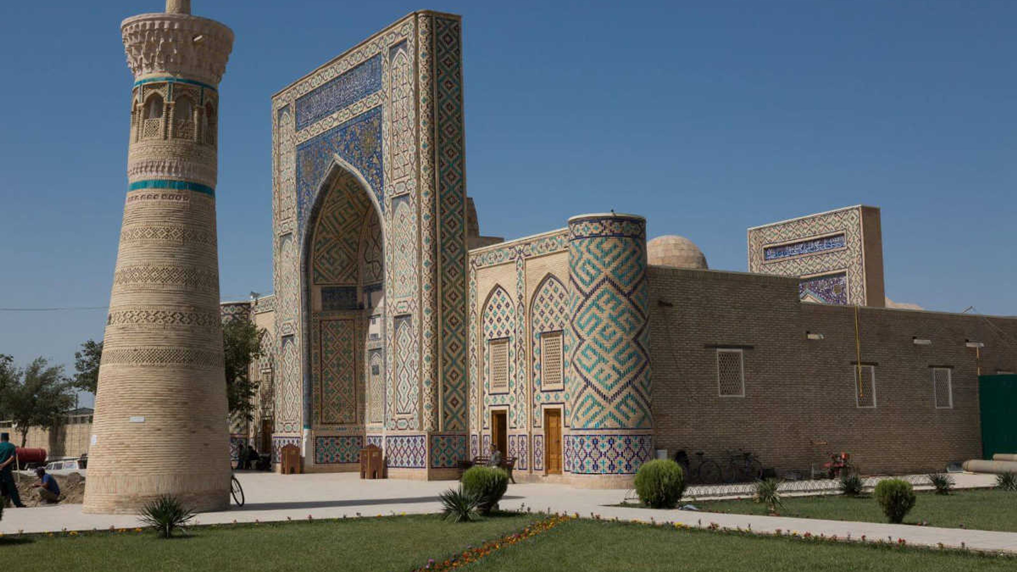 Madrasah Oulougbek à Gijduvan, Ouzbékistan : Monument historique avec portail en mosaïque bleue et minaret.