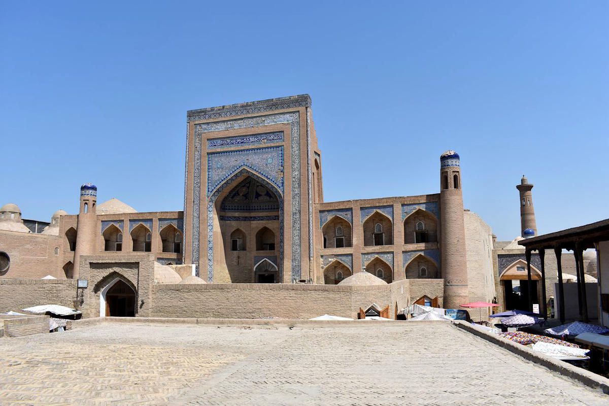 Allakuli Khan Madrasah in Khiva, Uzbekistan: Historic landmark featuring blue tiled portal and Islamic architecture.