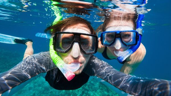 Adventurous couple goes snorkeling along the shores of Hawaii