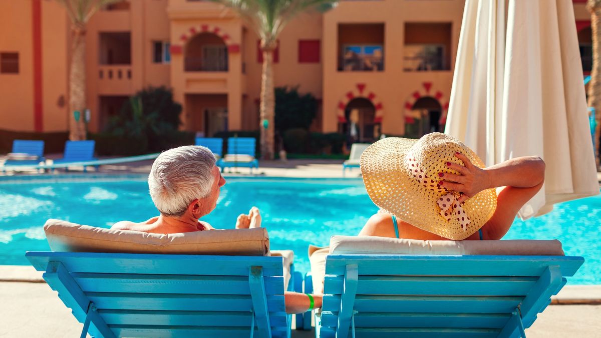A couple enjoying a conversation beside the pool at an all inclusive resort near their home in California