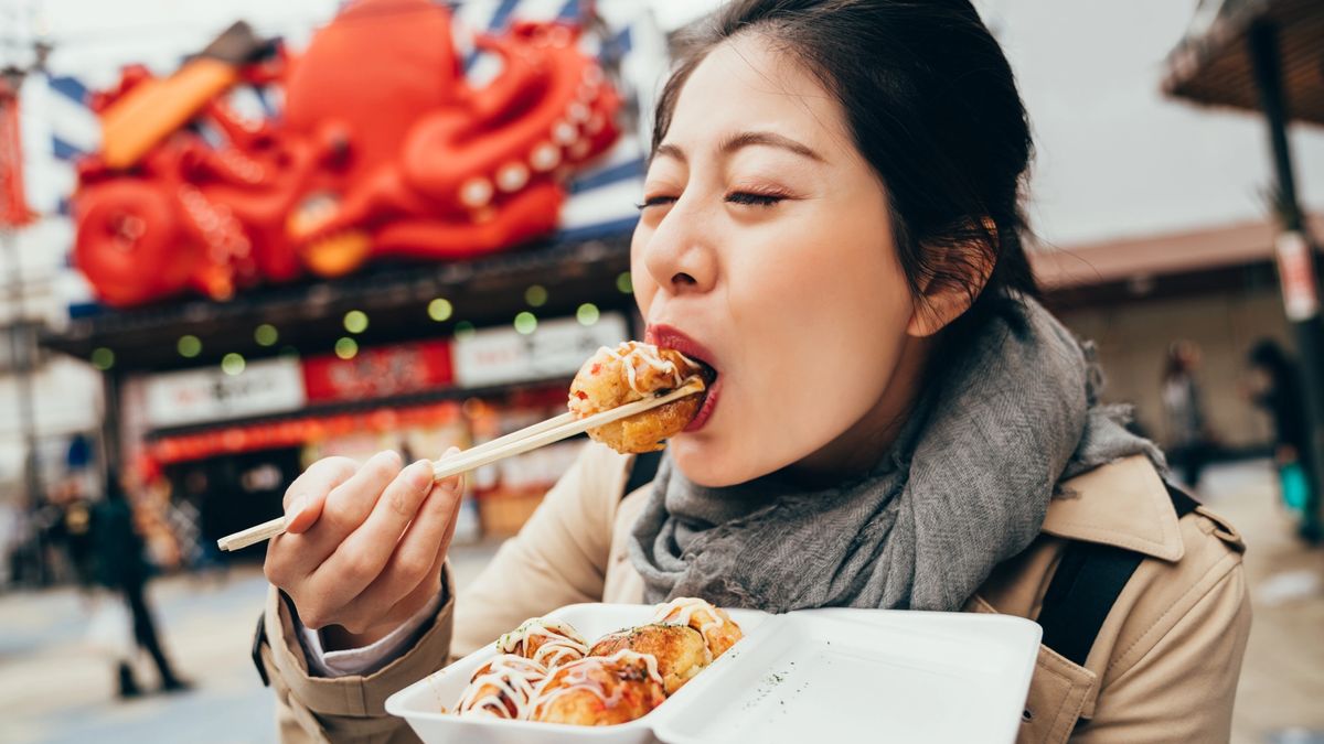 A tourist eating delicious vegetarian tacoyaki balls