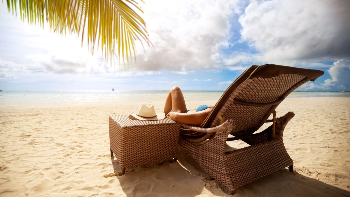 Woman on a luxury vacation in a leisurely beach-side chair.