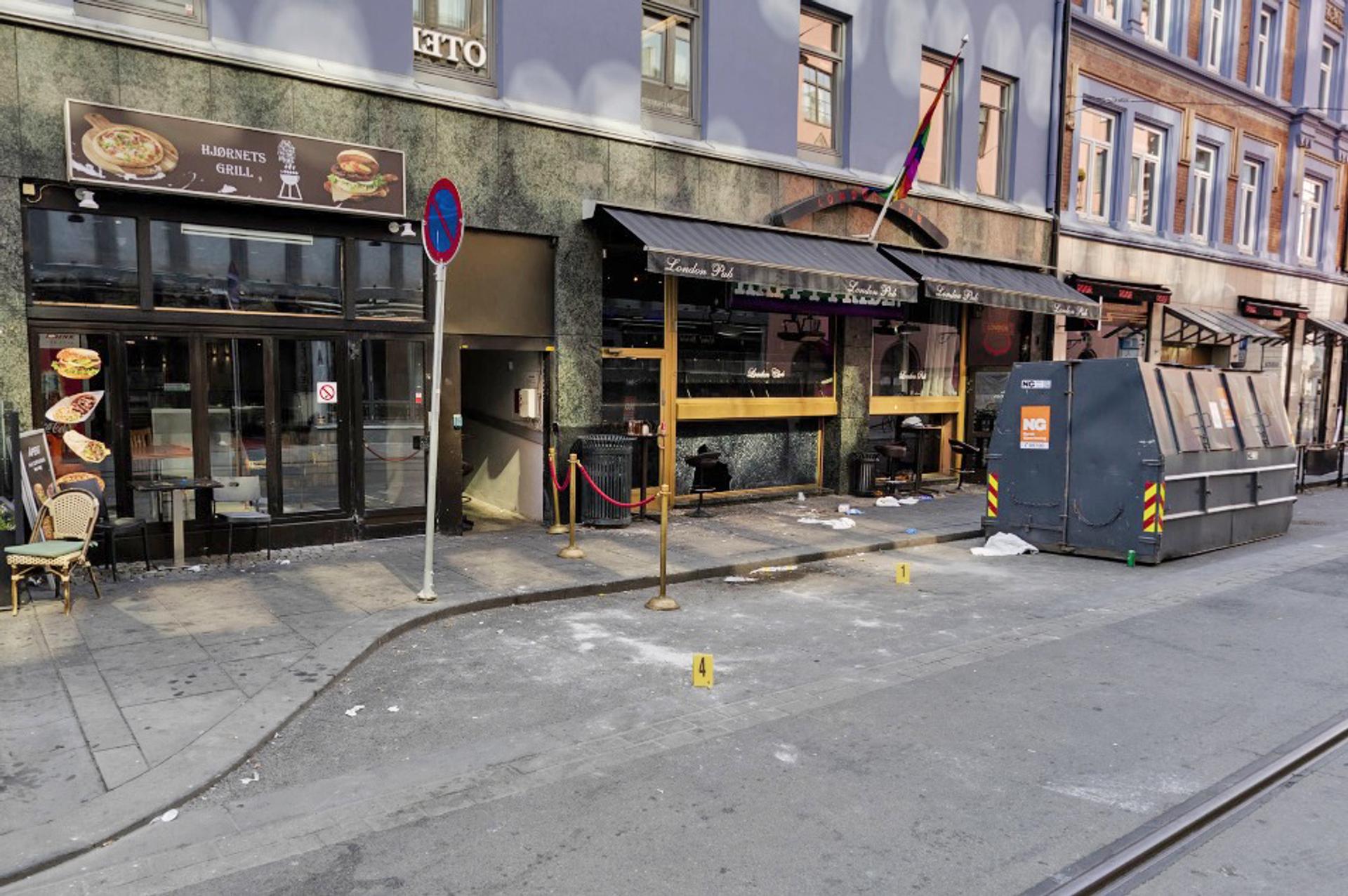 Fronten på London Pub og Hjørnets Grill og Kebab. Det står gule nummerskilt som markerer funn i gata.