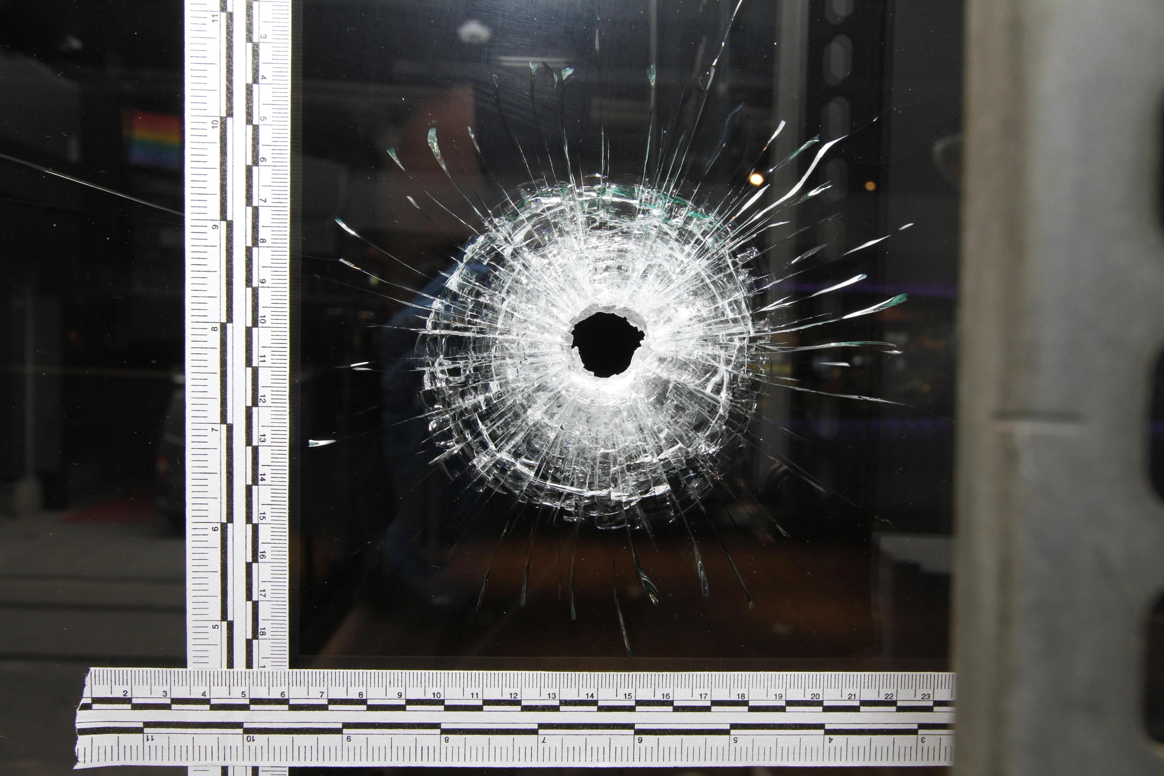 Skuddhull i et vindu med linjal ved siden av.