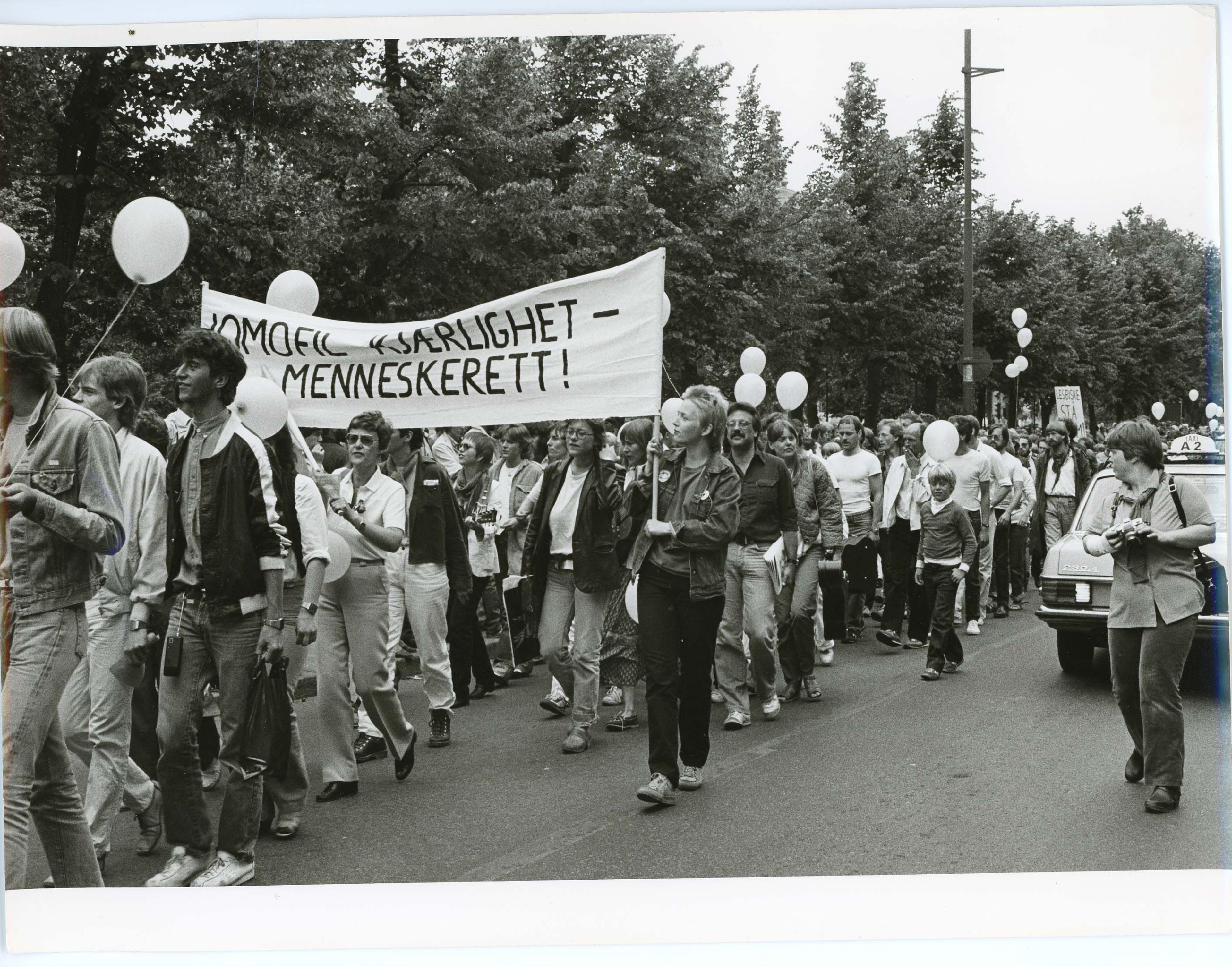 Demonstranter bærer en parole med slagordet «Homofil kjærlighet – Menneskerett!»