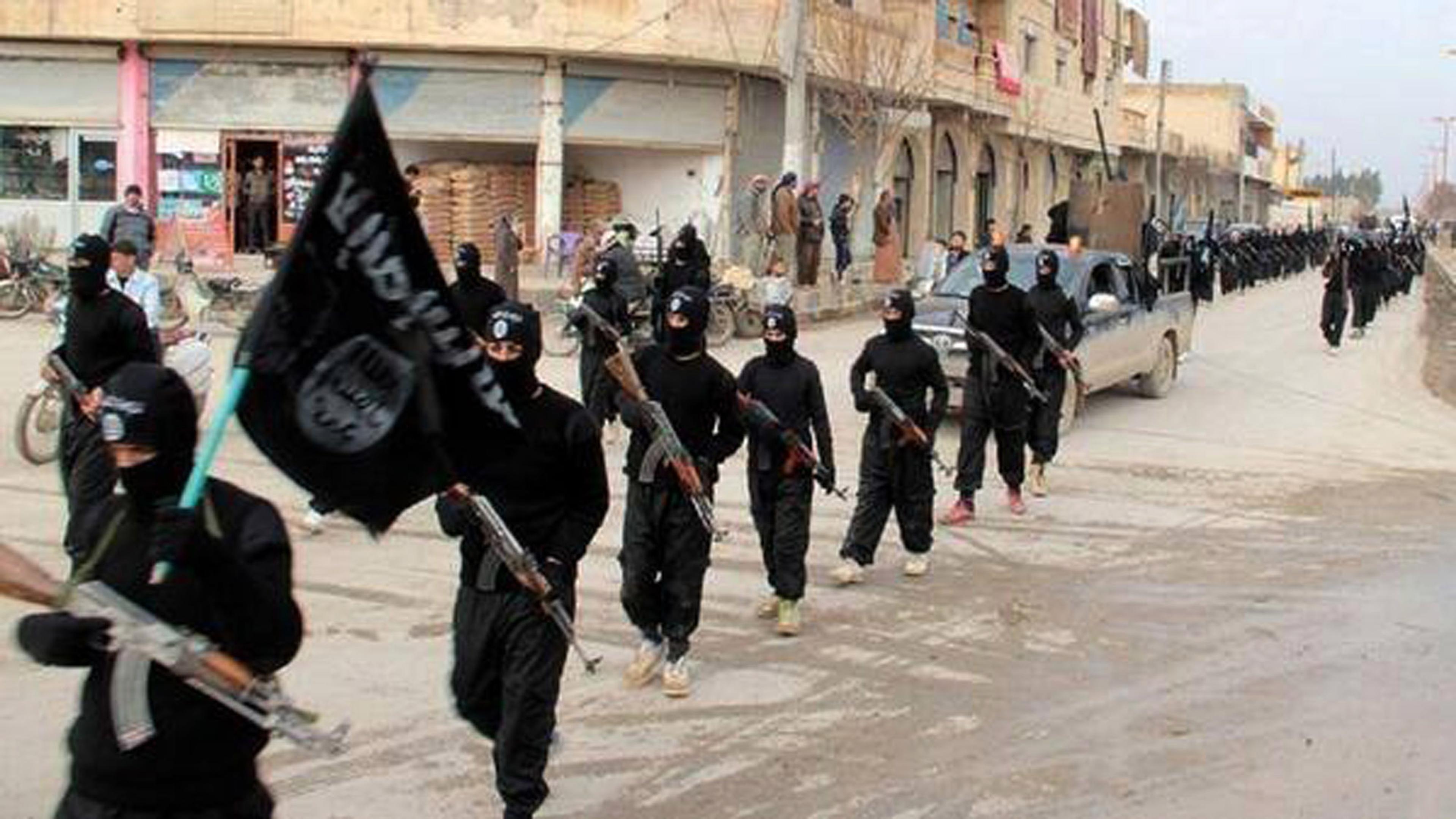 IS-krigere i sort marsjerer i Raqqa, som da var hovedstad i det erklærte kalifatet.