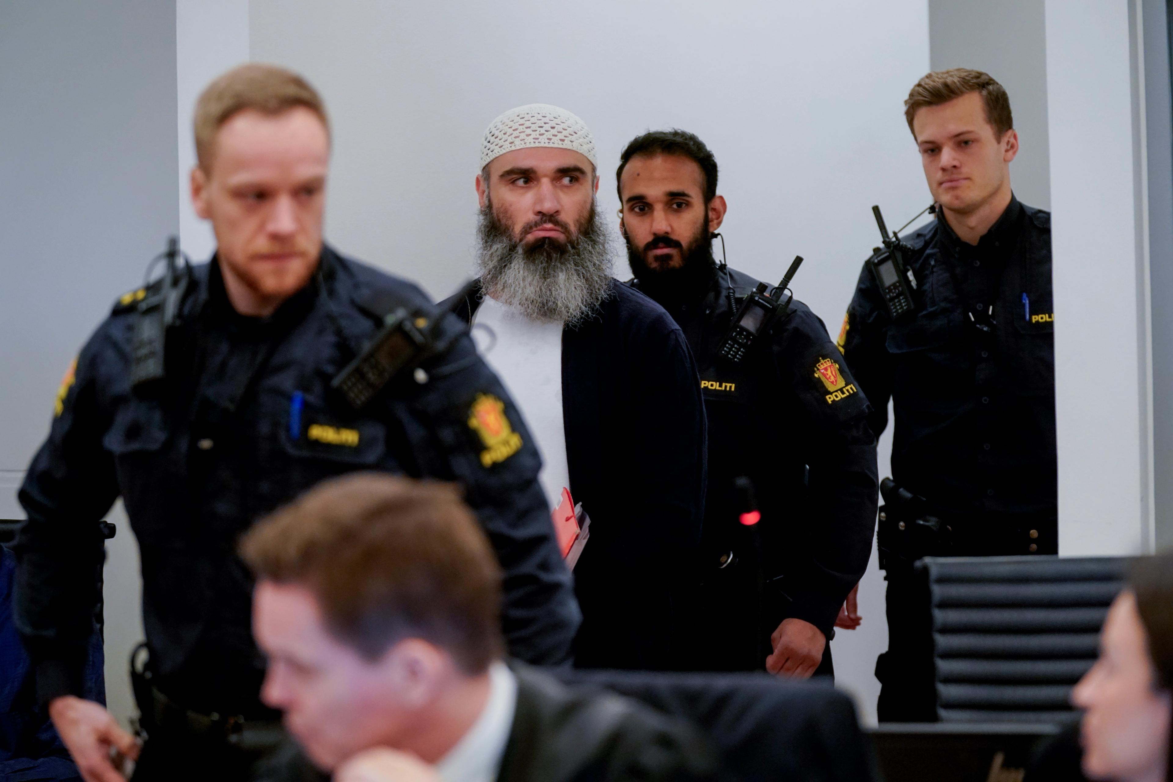 Zaniar Matapour på vei inn i tingrettssal 250. Han voktes av tre politibetjenter.