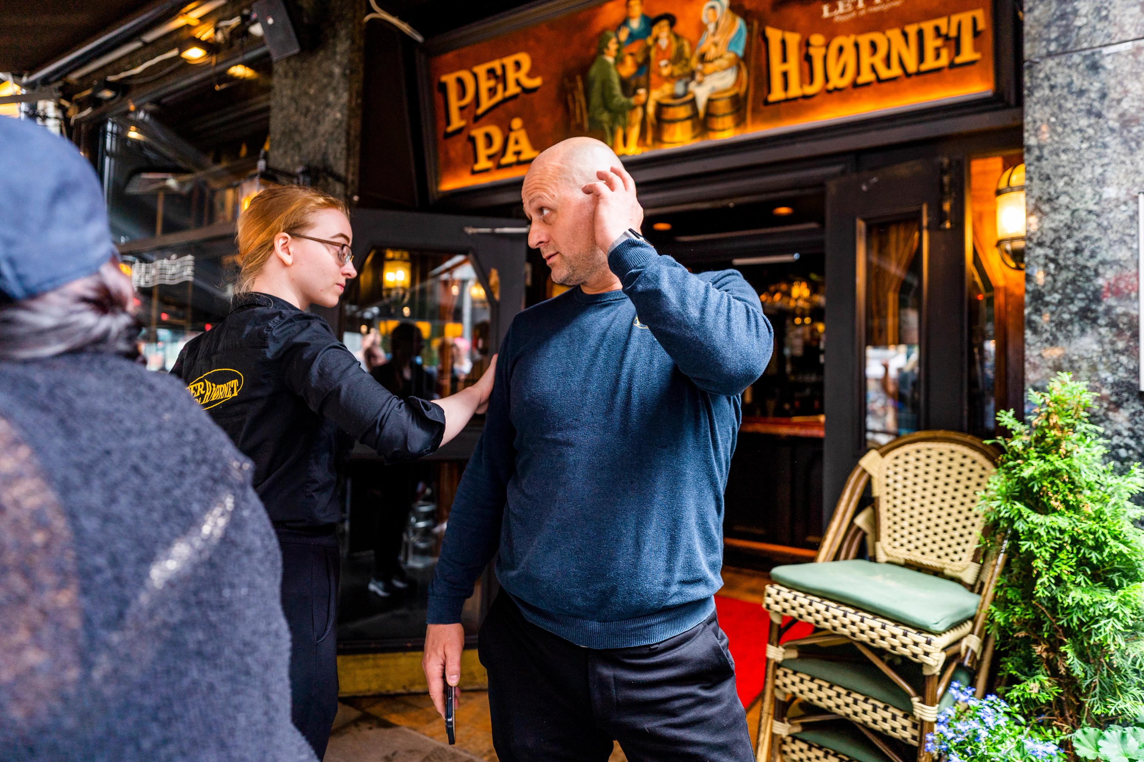 Innehaver Tadzedin Fetisi står utenfor Per på hjørnet. En av de ansatte holder ham på skuldra mens hun passerer.