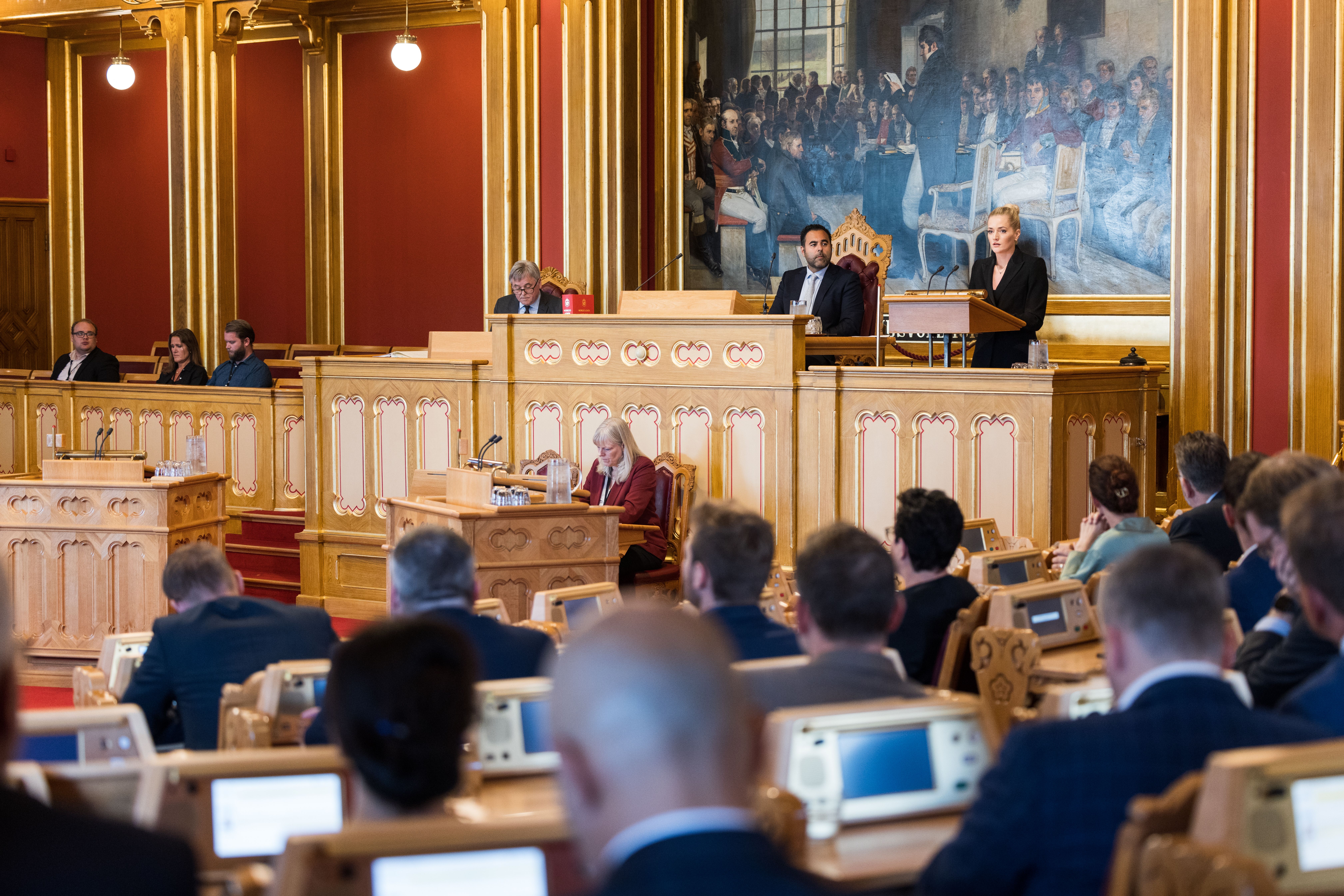Justis- og beredskapsminister Emilie Enger Mehl står på talerstolen i Stortinget, stortingspresidenten sitter ved siden av.
