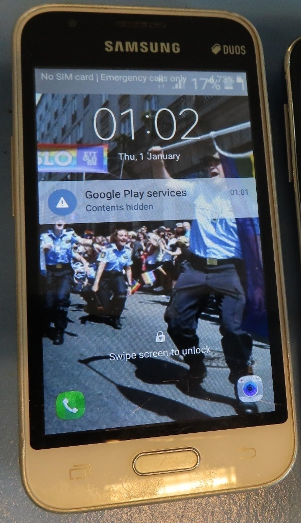 Matapours mobiltelefon med bakgrunnsbilde av politiet i pride-paraden