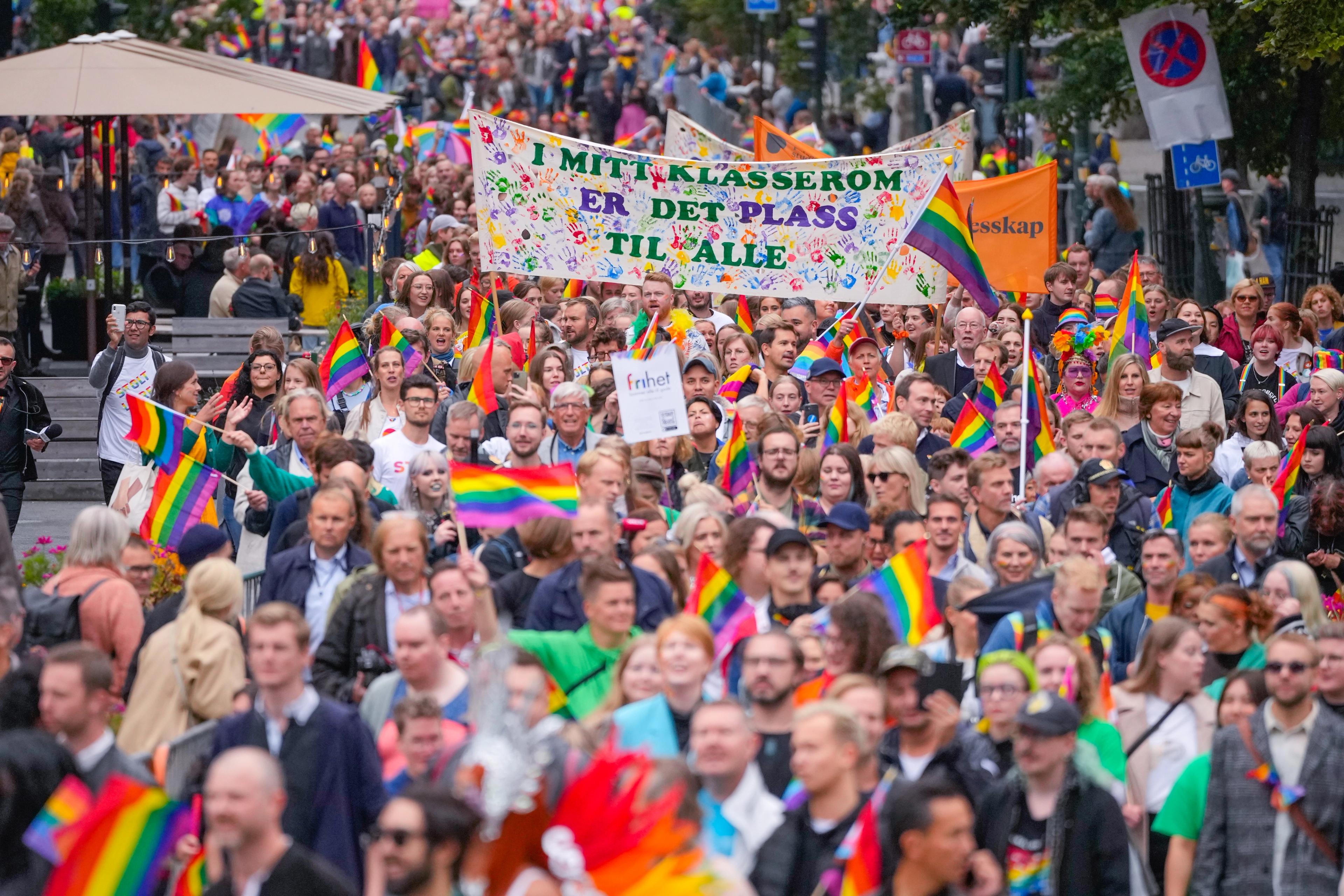 Regnbuetog i Oslo med pride-flagg og bannere.