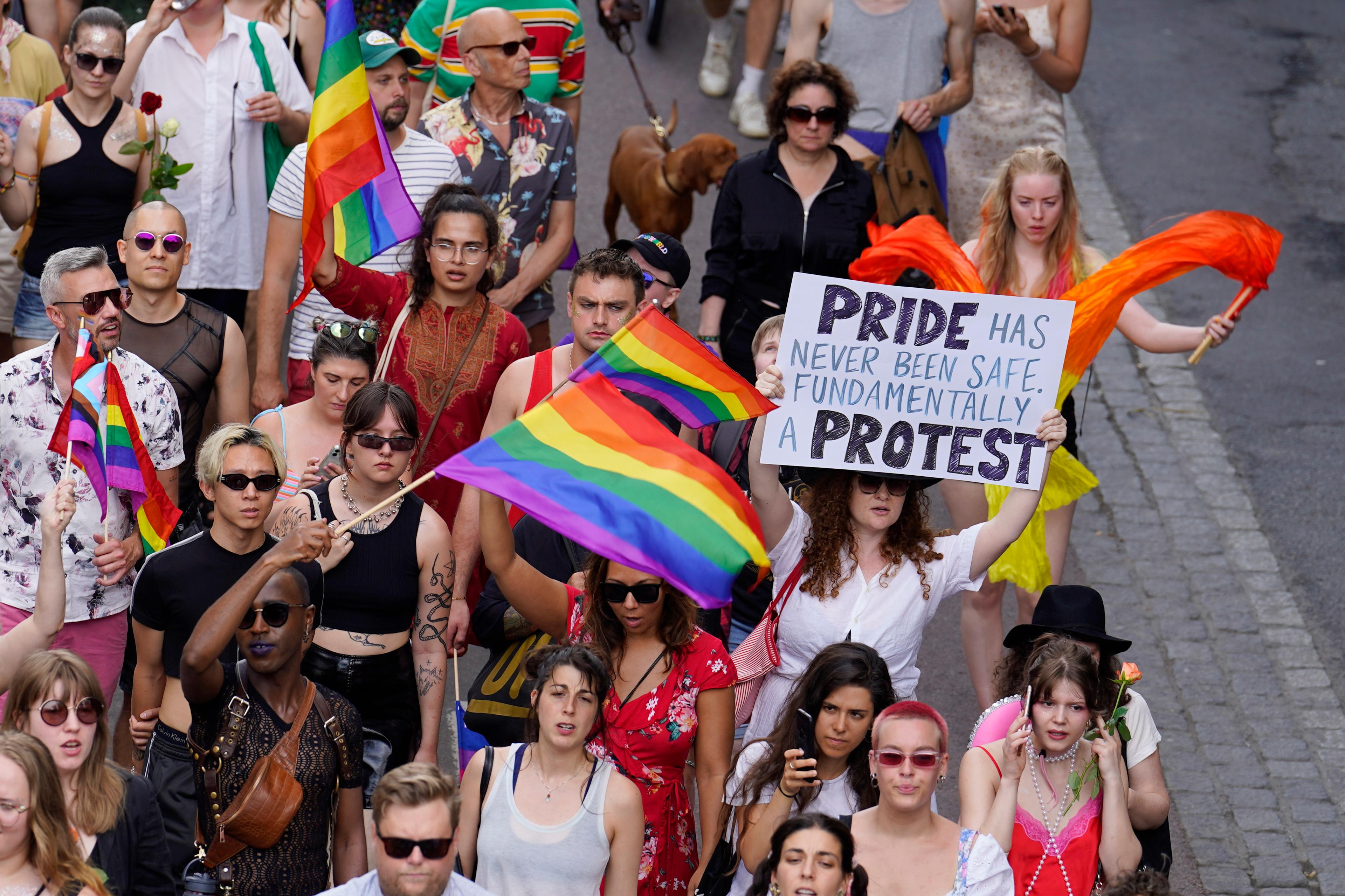 Demonstranter holder pride-flagg og en plakat med teksten «Pride has never been safe. Fundamentally a protest»