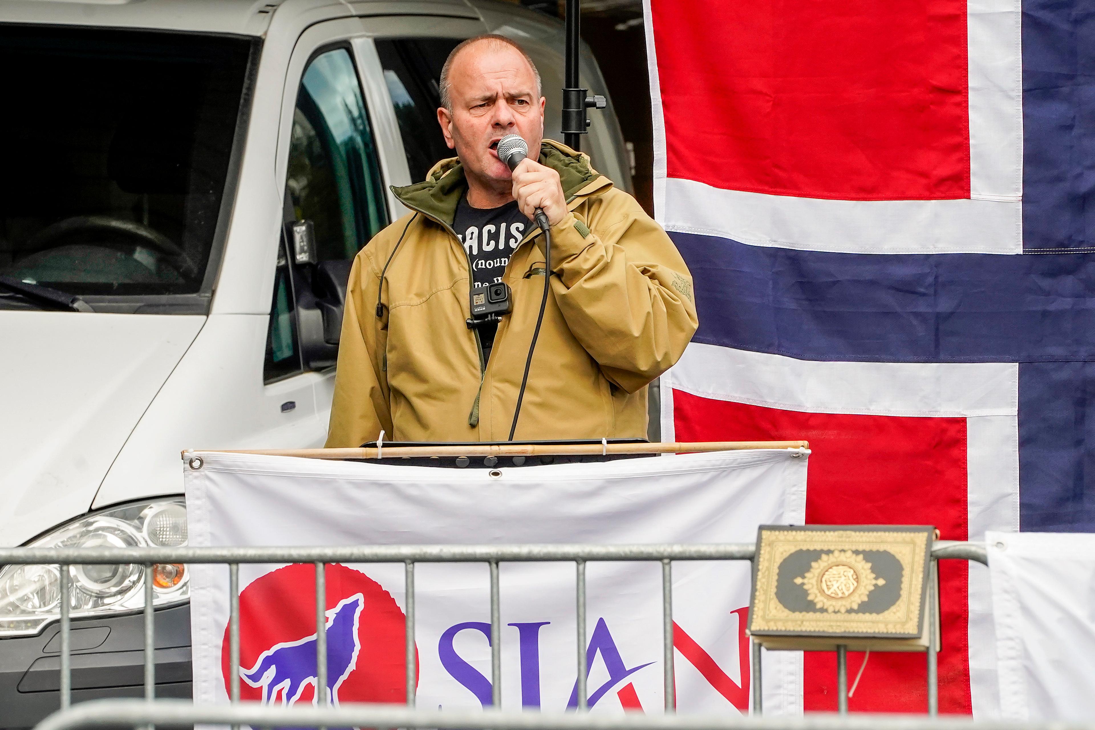 SIAN-leder Lars Thorsen taler under en markering. Har har norsk flagg, SIAN-banner og en Koran.