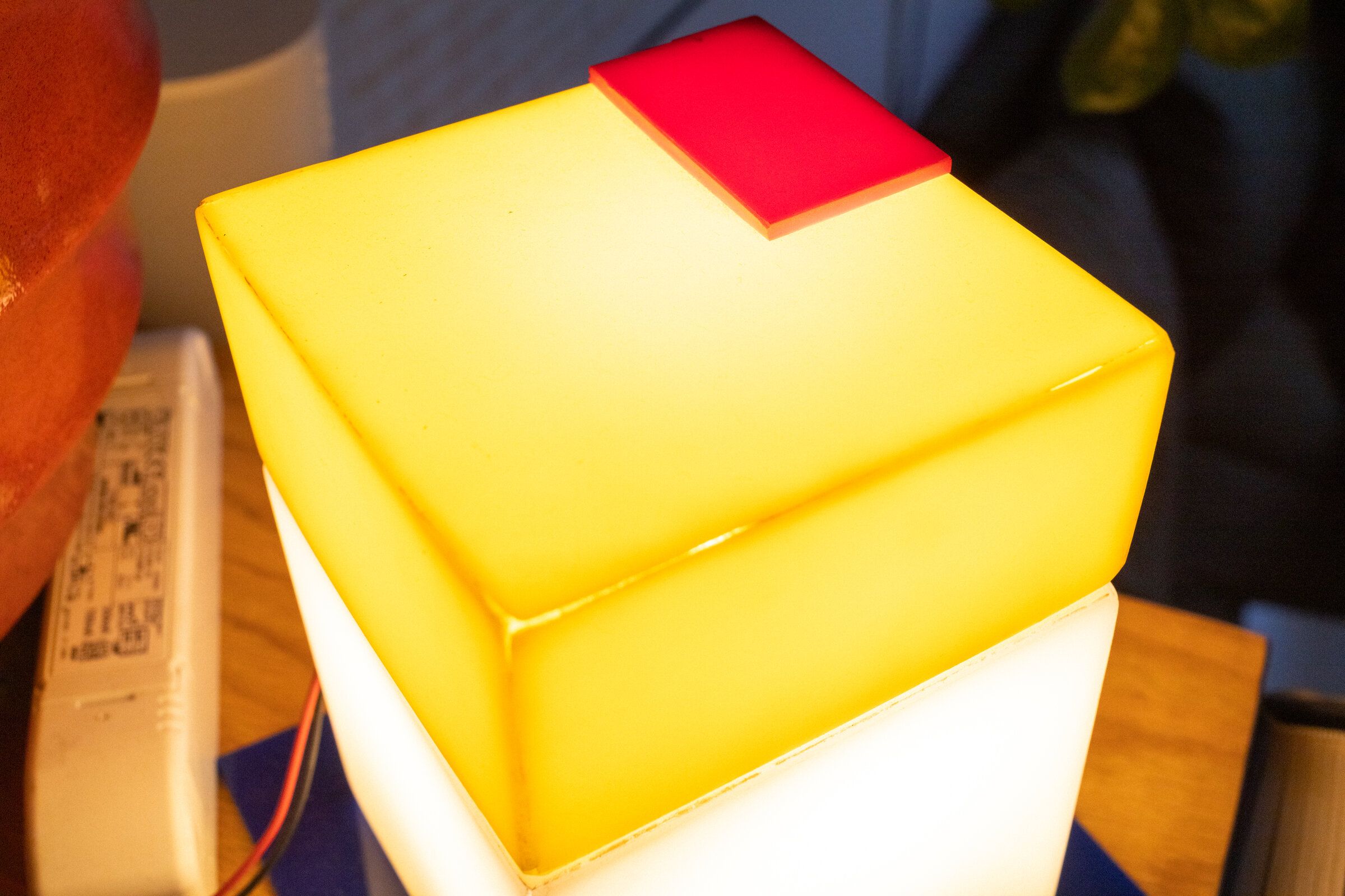 Top-down view of parts and all: the yellow cap with its mitered corner seams visible, a small red square offset to one corner