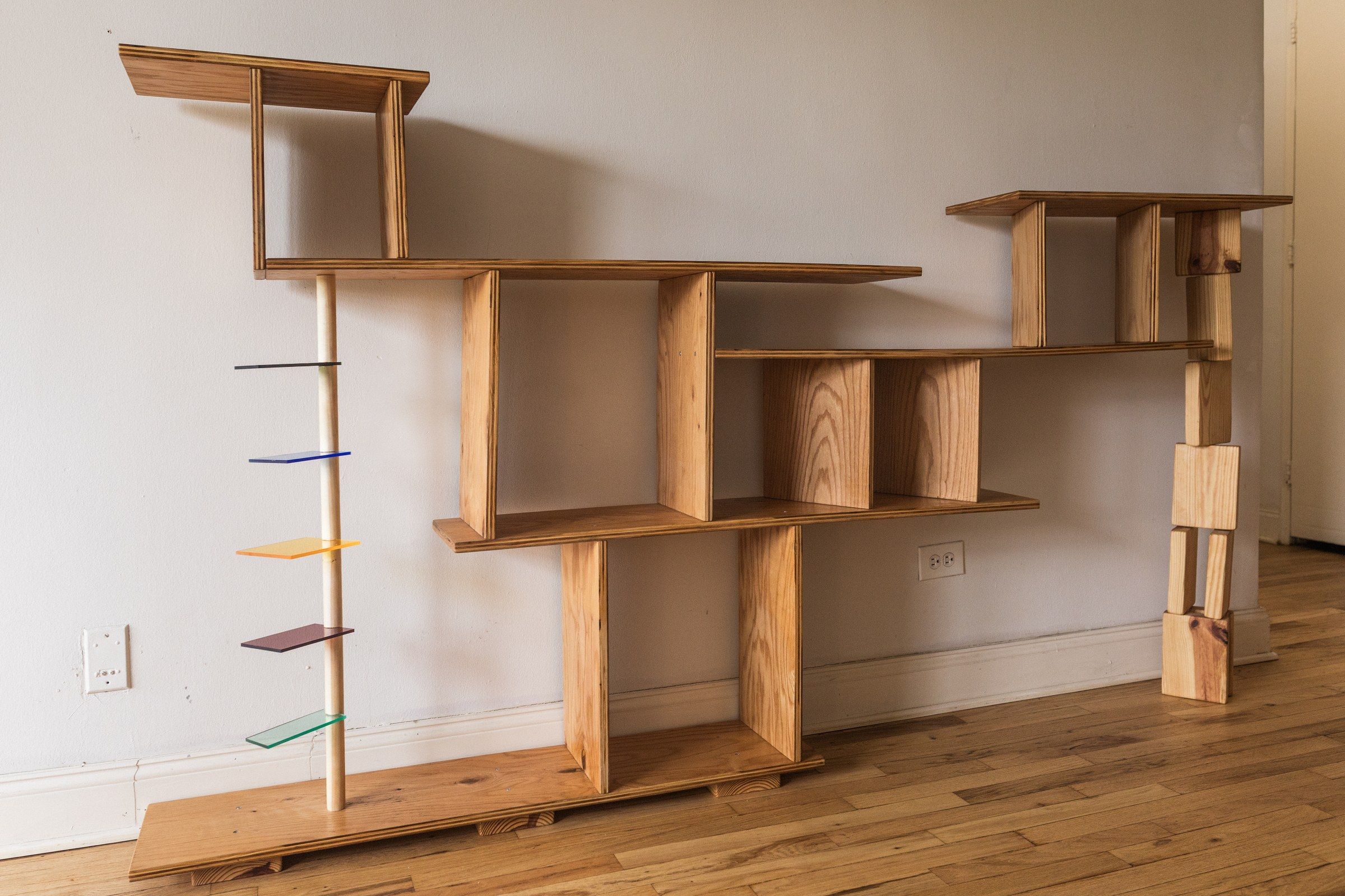 Closer view of the shelving unit's compartments, the grain of the wood and a warm glow within.