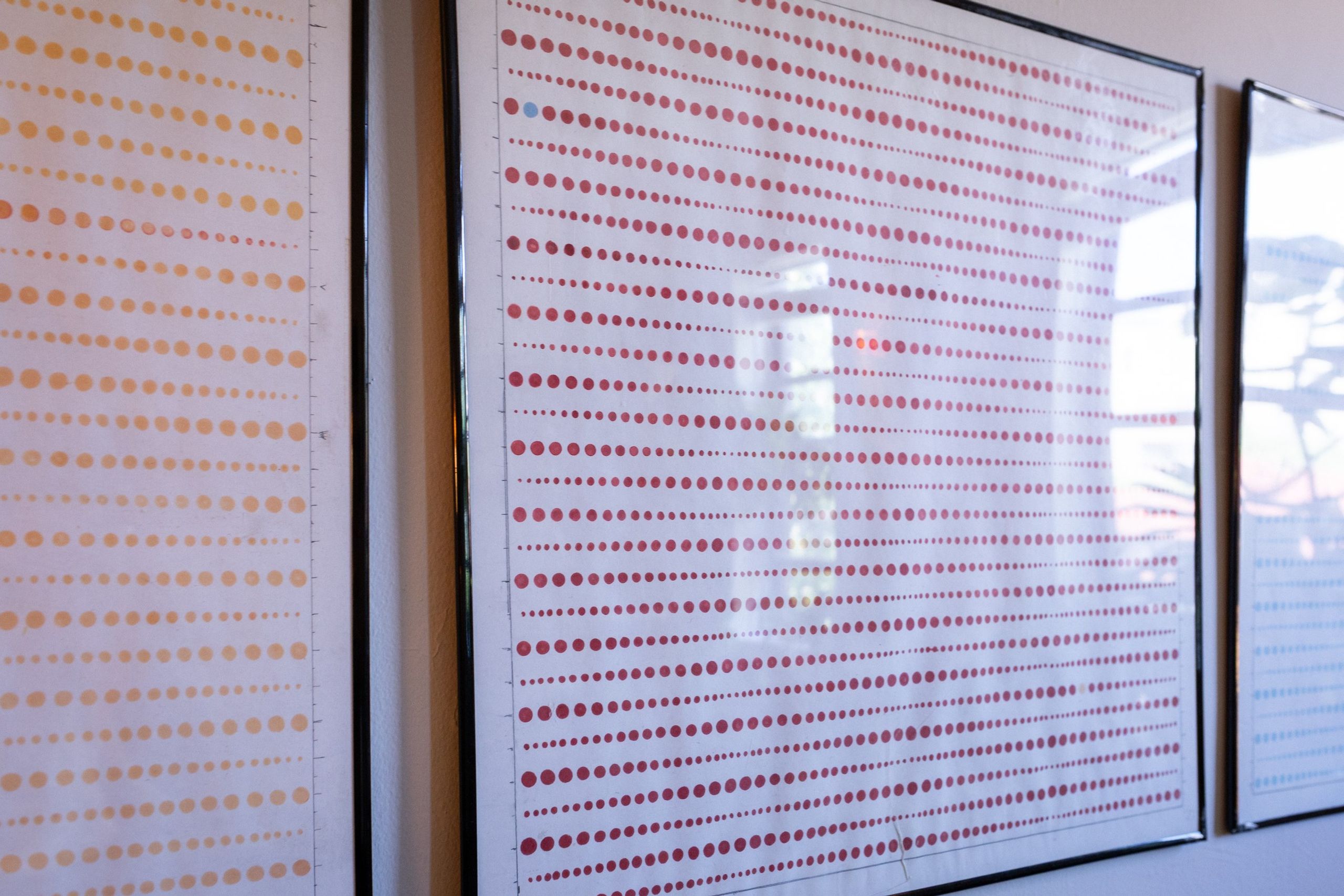 Edge of a framed dot drawing, the marker grid fading into pale ground.
