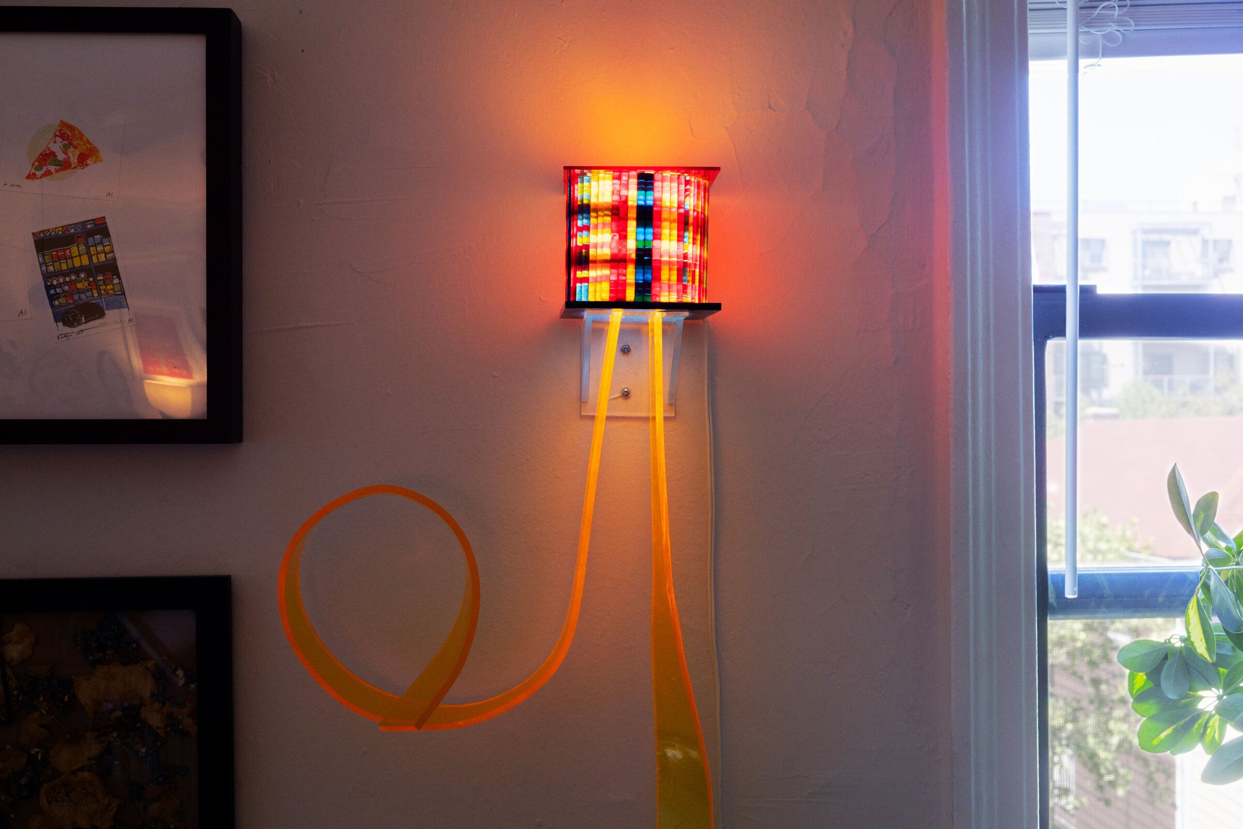 I've been thinking about flowers from closer: a square box of densely packed colored vertical elements lit from within, a long orange ribbon descending in a curling loop below