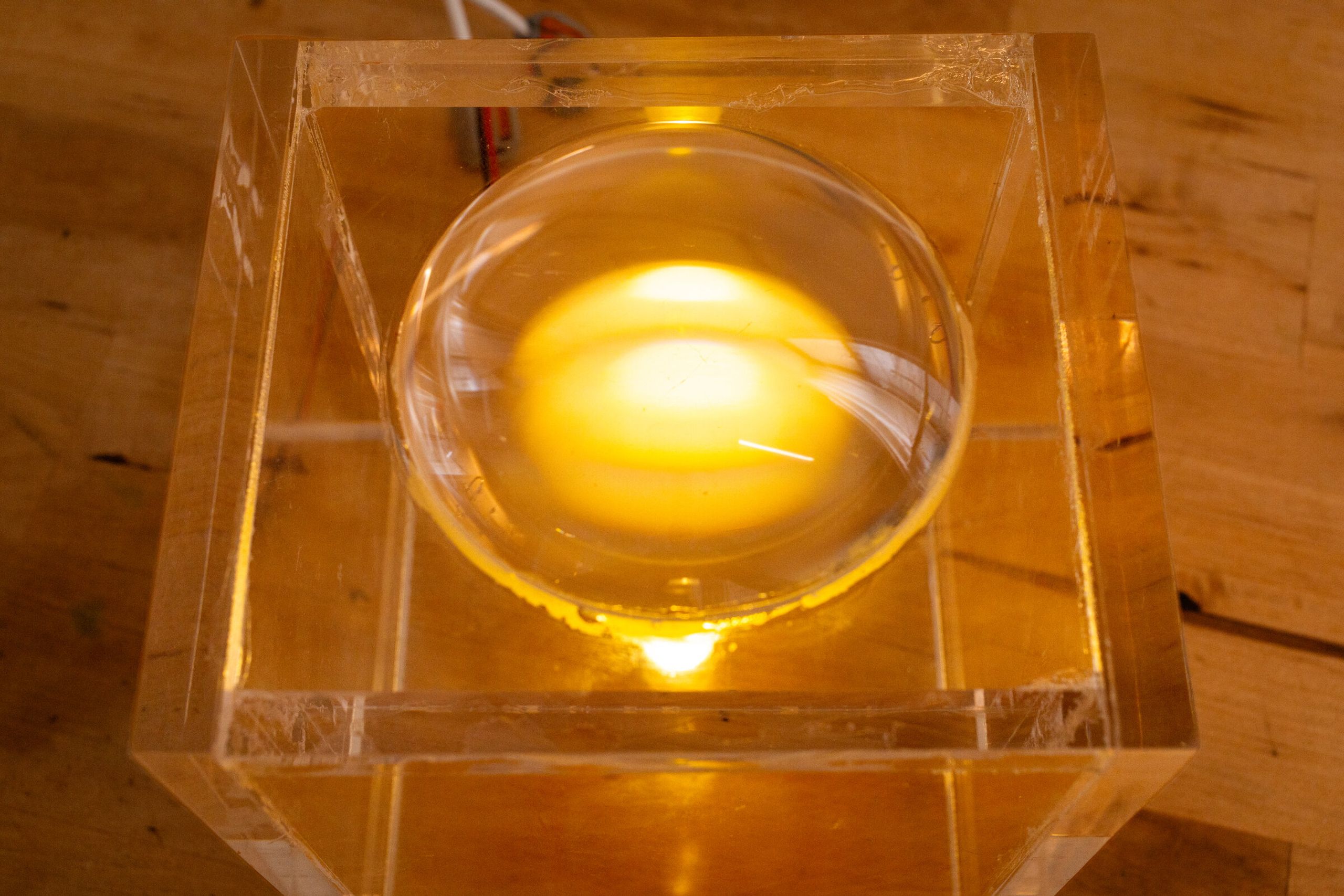 Closer top-down view through the lens of internal artifact: the magnified yellow scroll visible underneath, held in a warm halo