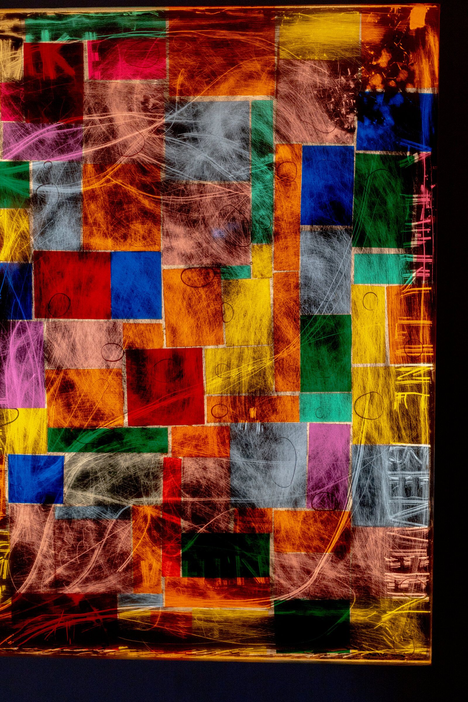 Vertical close crop of genius madness mirror: colored squares more strongly saturated, scratched white gesture moving across, edge of frame visible
