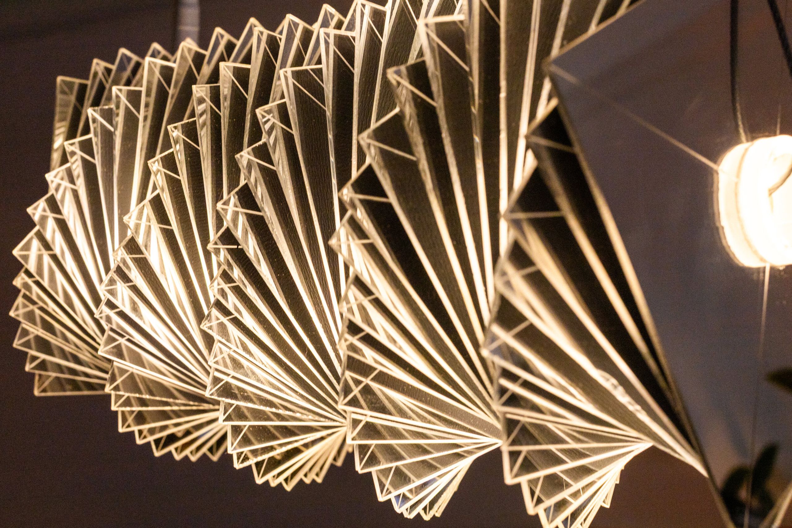 Close angled view of radiator III: mirrored plates catch the room, the form thinning as the eye finds the gaps between them