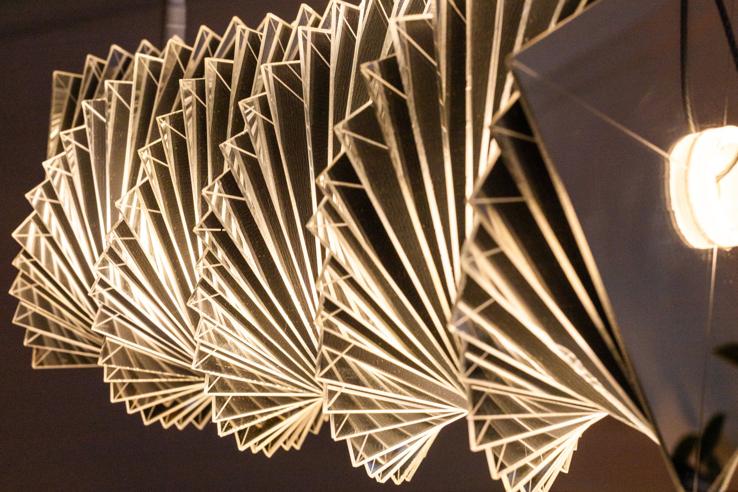 Close angled view of radiator III: mirrored plates catch the room, the form thinning as the eye finds the gaps between them