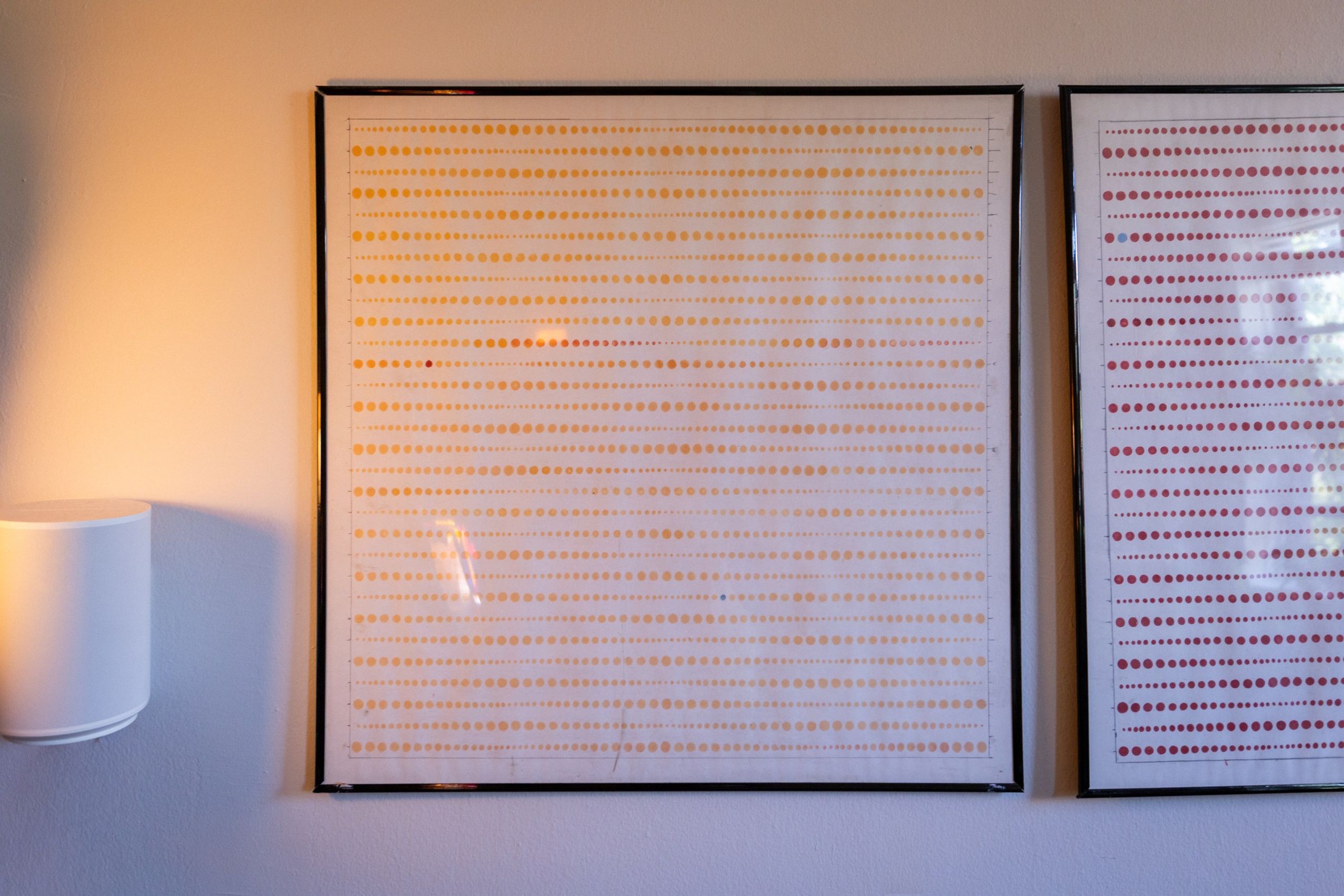 A single dot drawing up close: a faint grid of marker dots across pale translucent paper.